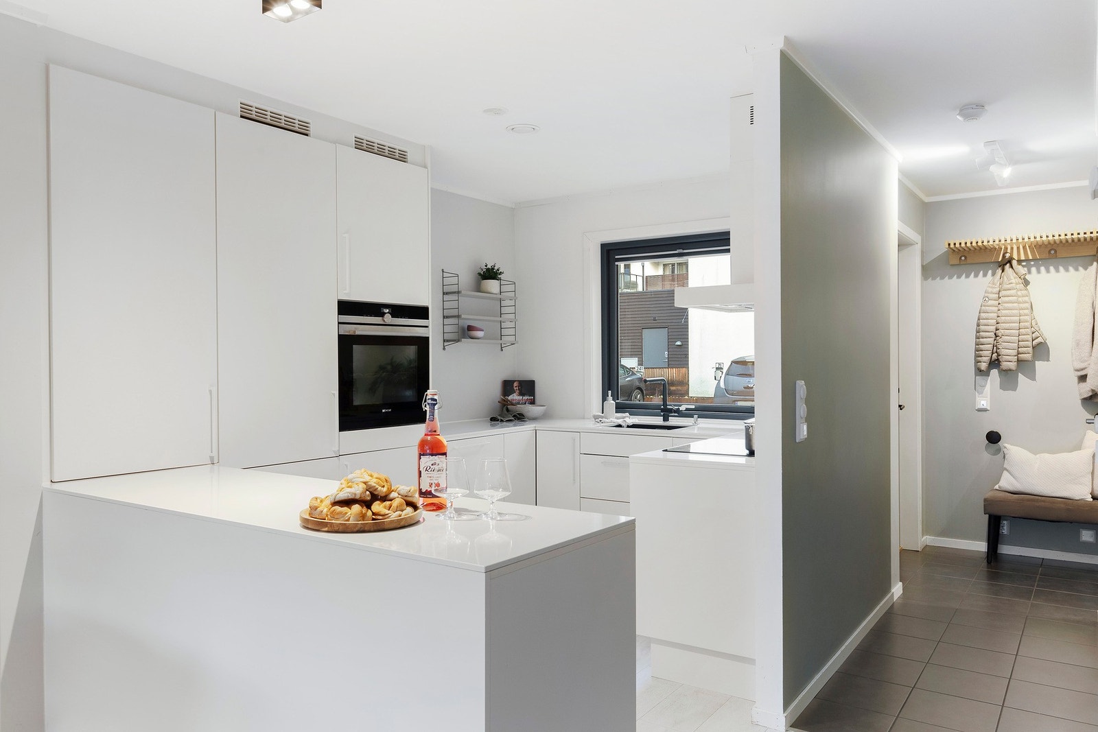 Den praktiske halve kjøkkenøya gir god ekstra benkeplass og bidrar til en åpen, men tydelig overgang mellom kjøkken og stue Galleribilde