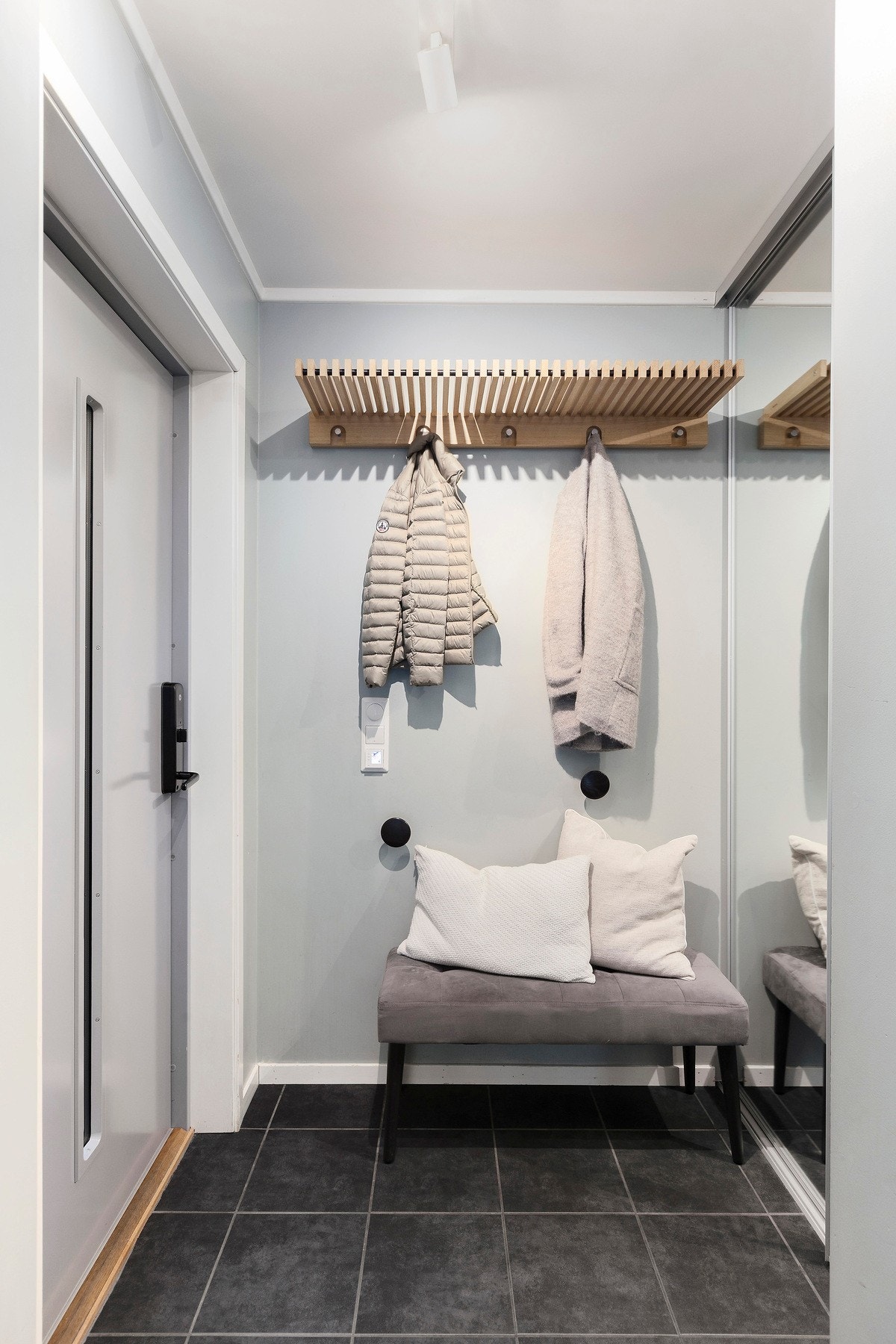 Lys entré med praktiske fliser på gulv og integrert garderobe med speildører Galleribilde