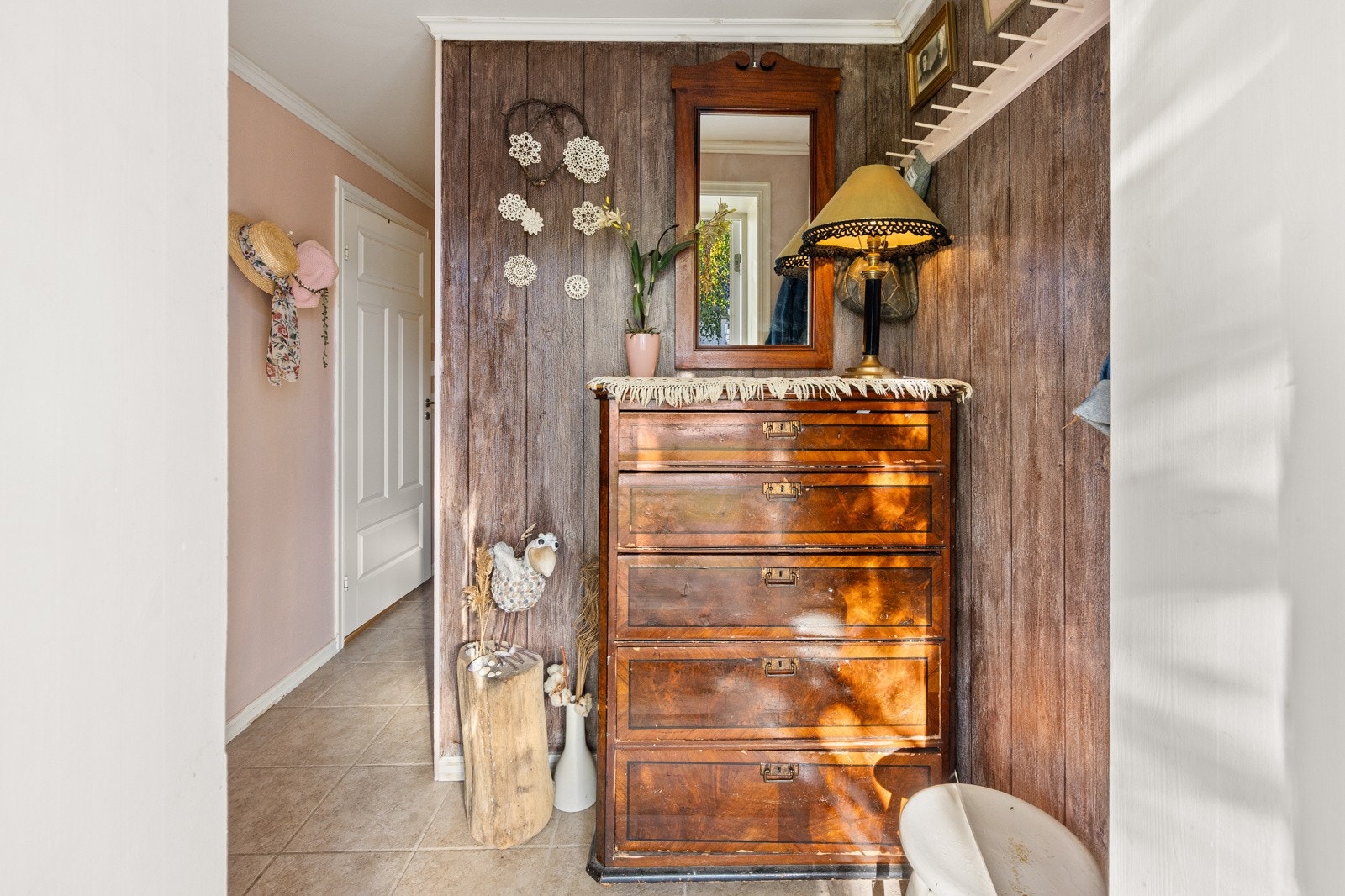 En hyggelig entre ønsker deg velkommen inn. Entréen har flislagt gulv med behagelig gulvvarme og vegger med malt strietapet, noe som gir et rent og praktisk førsteinntrykk. Galleribilde