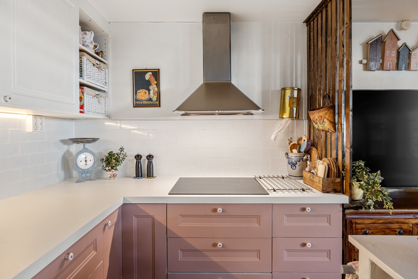 Innredningen har profilerte fronter og laminert benkeplate med nedfelt vaskekum, samt fliser på vegg mellom over- og underskap. Under overskapene er det montert belysning som gir godt med arbeidslys. Galleribilde