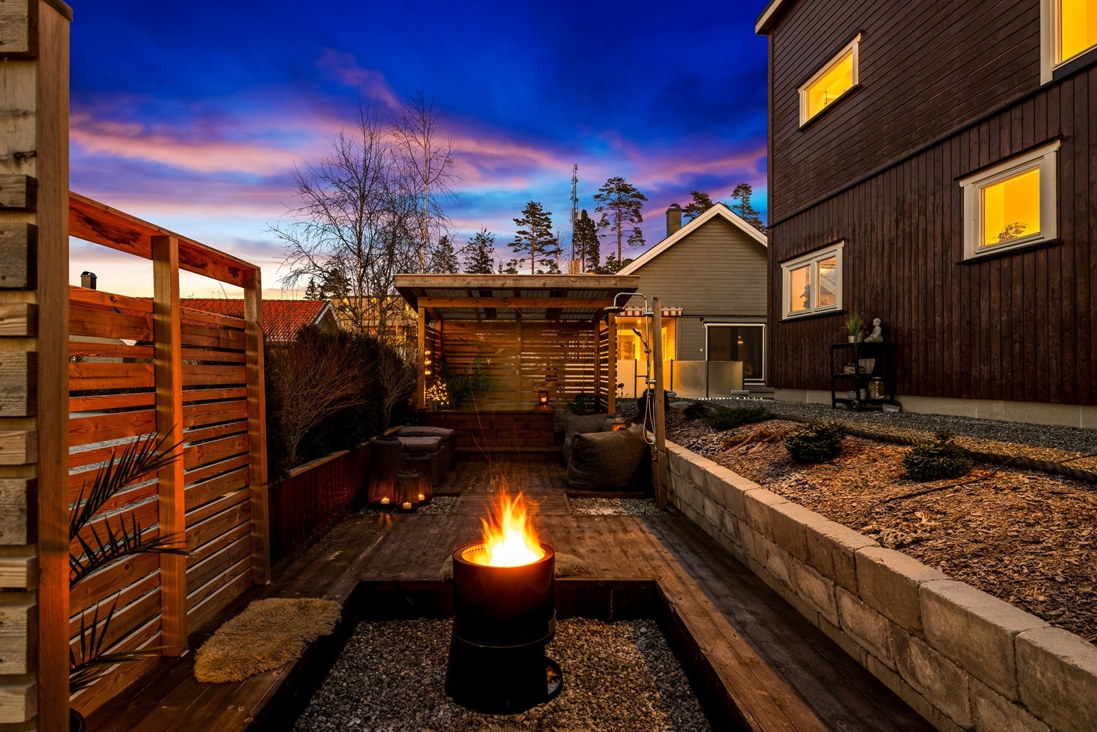 Betongstein og treverk gir en solid ramme rundt ildstedet på uteplassen (kilde: tilstandsrapport). Galleribilde