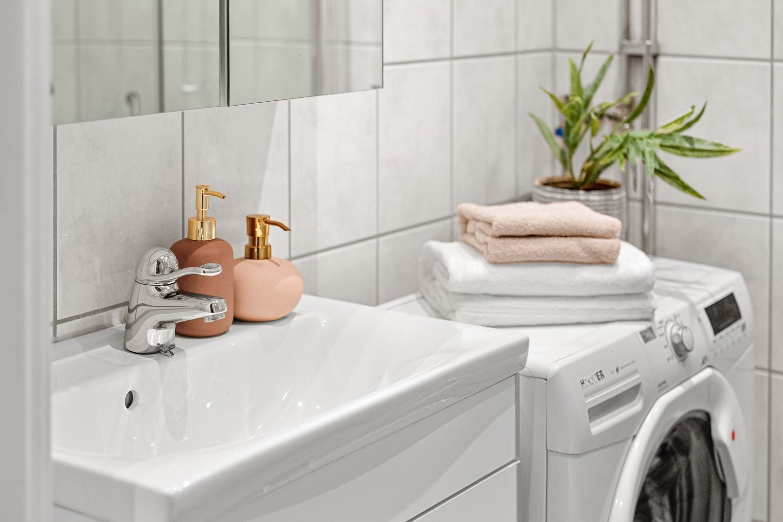 Baderomsinnredningen er bestående av benkeskap med glatte fronter. Veggskap med speilfronter over servant, håndkleholder i metall montert på vegg og vegghyller montert over klosett. Galleribilde