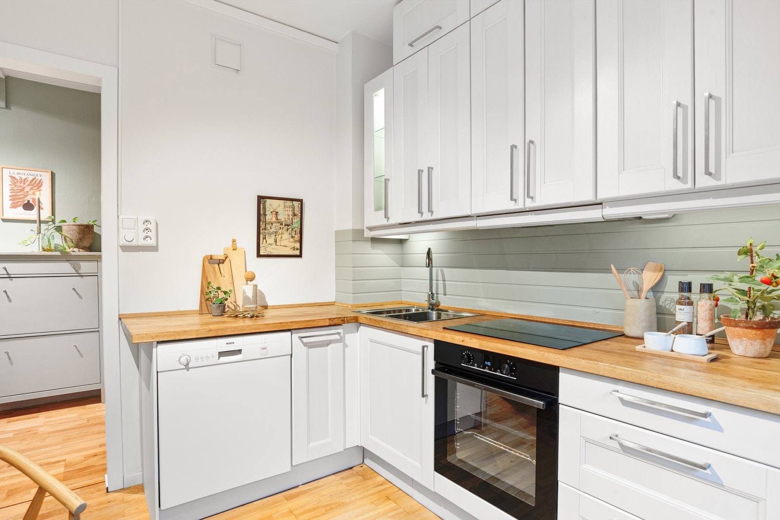 Et av overskapene har glassfront, videre er det stekeovn, koketopp, og kjøl/frys integrert i kjøkkeninnredningen. Galleribilde