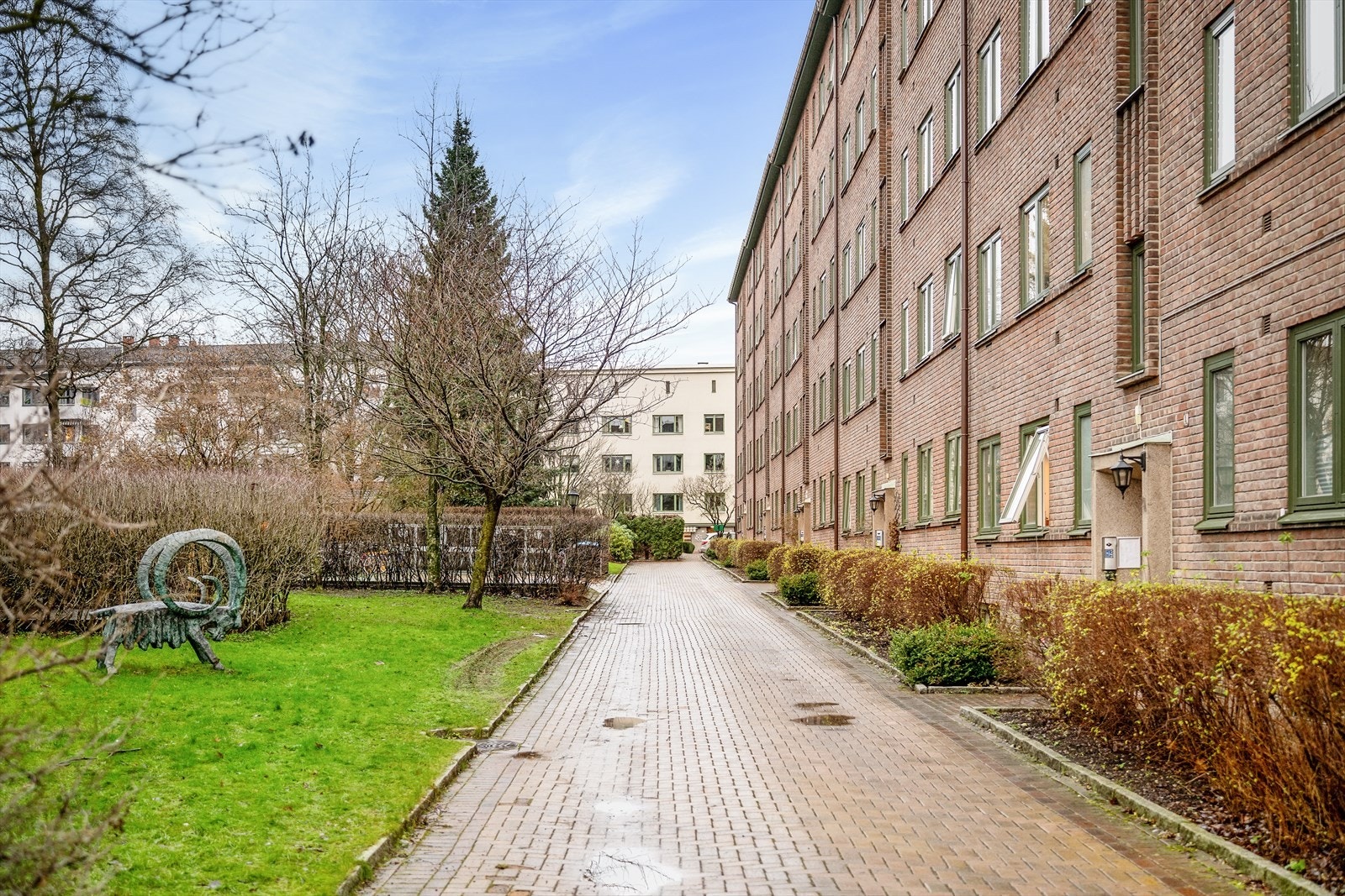 Koselige uteområder med skulptur, brostensbelagt gangvei og grøntområder. Galleribilde