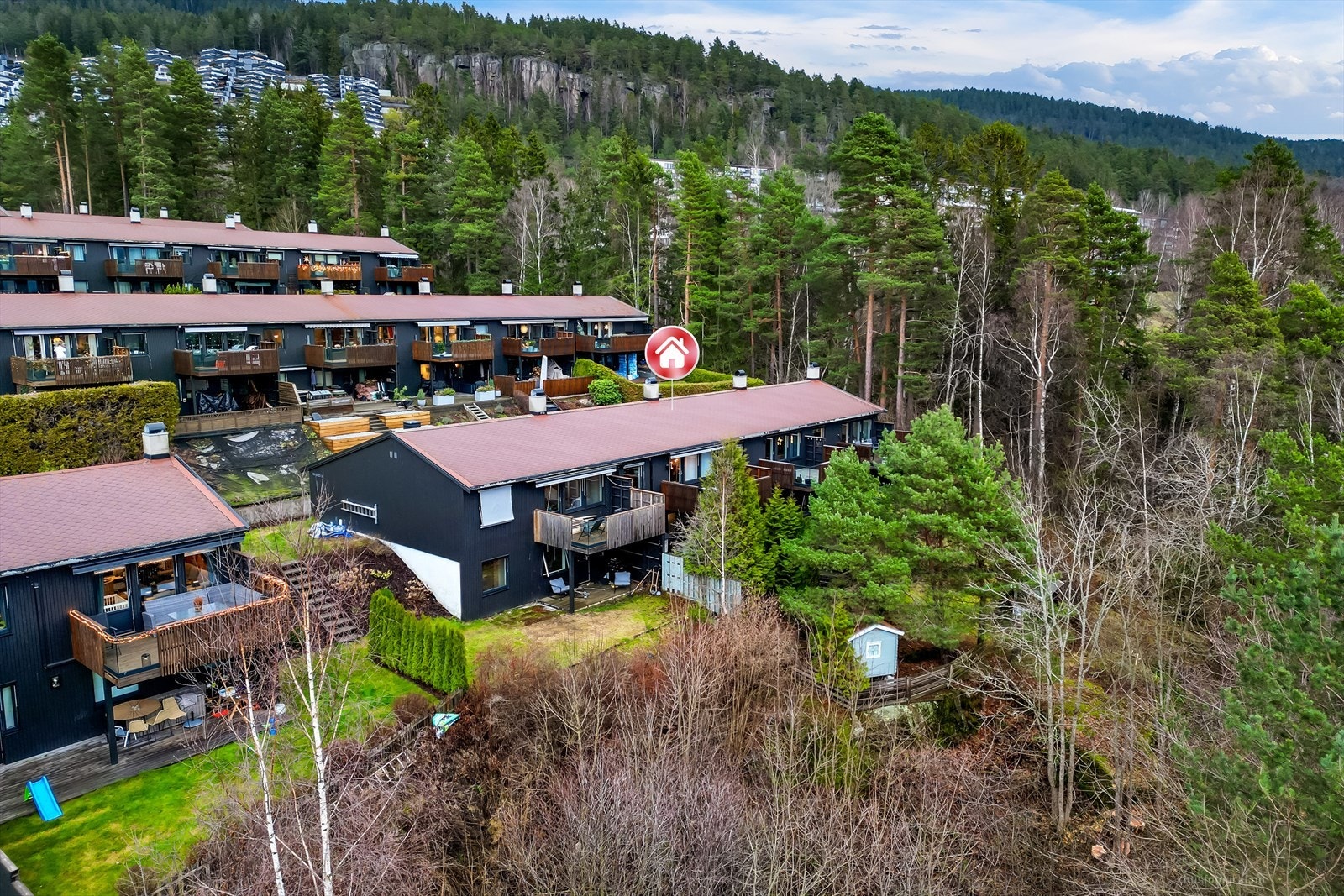 Boligen ligger skjermet med busker , plen og gjerde rundt hagen. Galleribilde