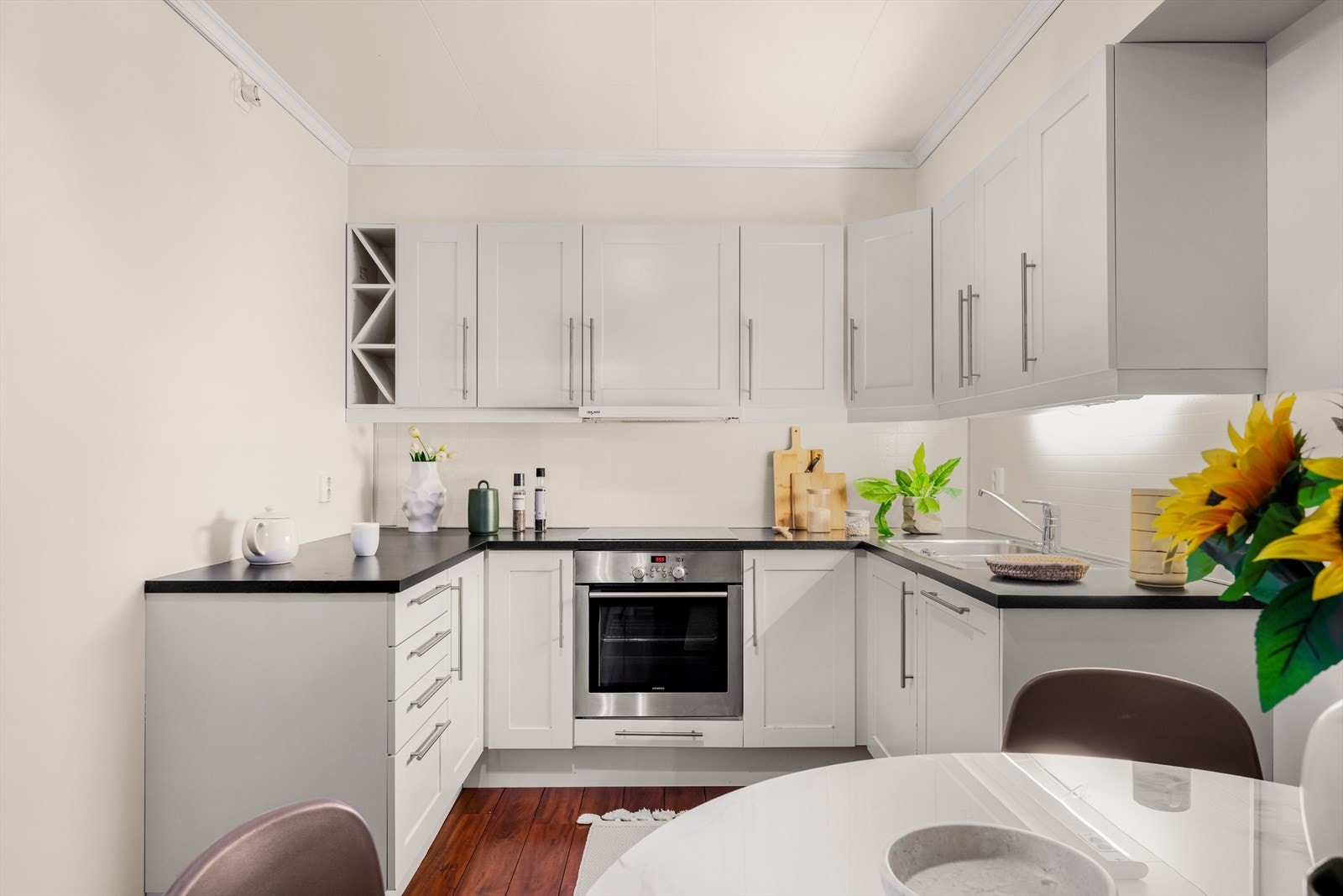 Stilrent og funksjonelt kjøkken som inviterer til matglede. Romslig og tidløst Sigdal-kjøkken med folierte skrog, profilerte fronter og laminert benkeplate som gir et klassisk og varig uttrykk Galleribilde