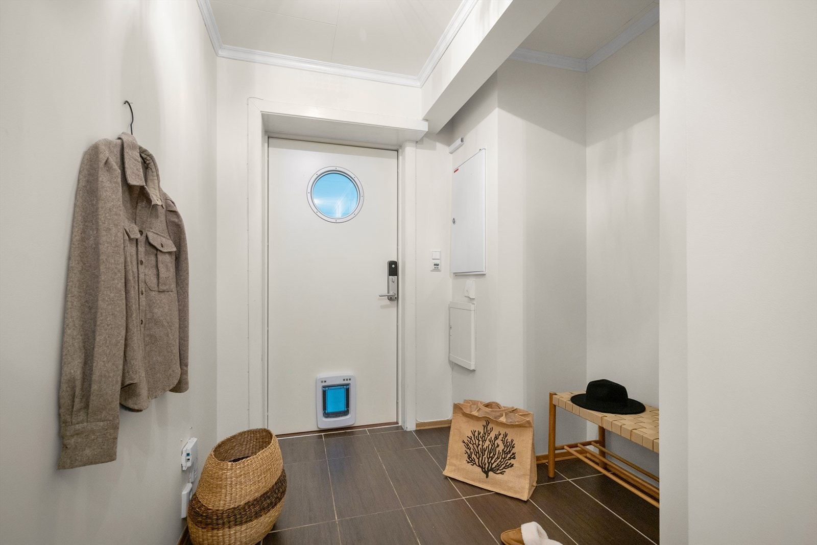 Et innbydende førsteinntrykk. Lys og romslig entré med pene farge- og materialvalg og med god plass til oppbevaring av yttertøy og sko gir en praktisk og ryddig hverdag Galleribilde