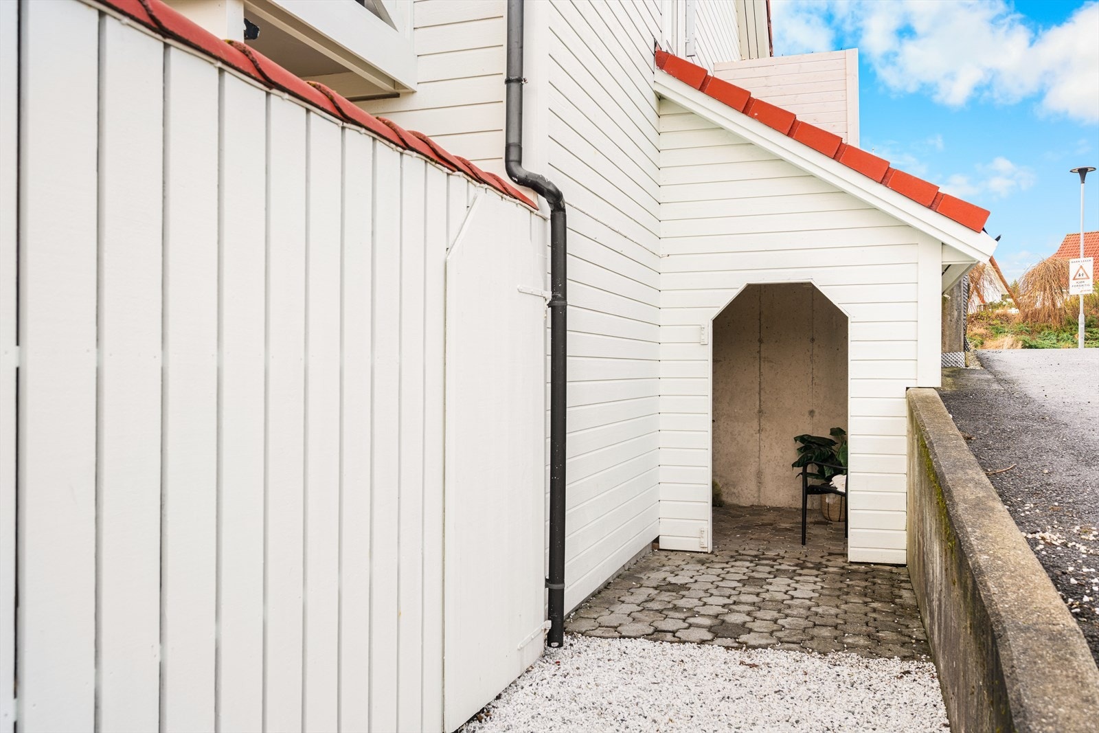 Lunt og skjermet inngangsparti som gir et ryddig og innbydende førsteinntrykk. Praktisk adkomst med overbygg gir ly for vær og vind Galleribilde