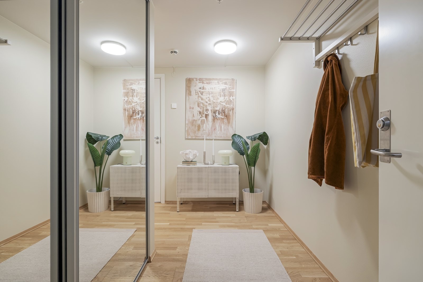 Parkettgulv og malte, slette vegger gir et rent uttrykk i entréen. Galleribilde