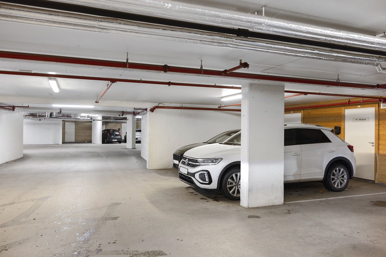 Parkering i felles parkeringskjeller. Adkomst parkering via felles nedkjøring. Det er elektrisk port, trapp og heis til leilighetene. Det montert elbil-lader i garasjeanlegg i 2022. Galleribilde