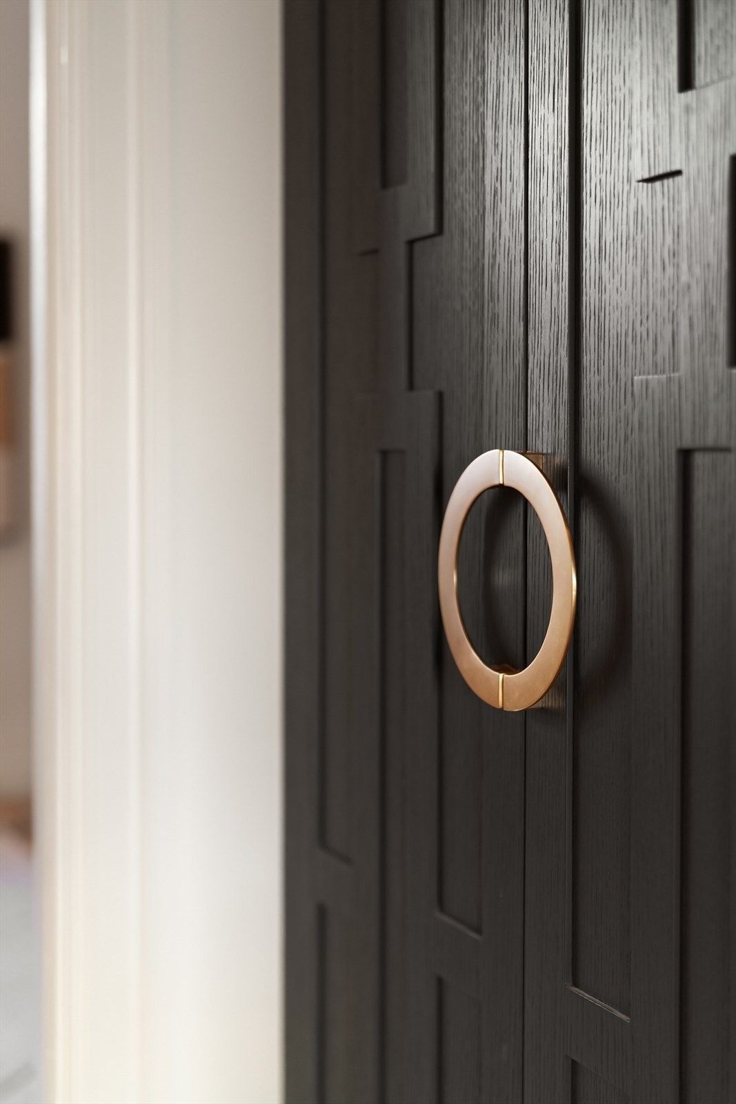 Garderoben har integrert belysning, stilrent relieff og håndtak i messing, i tråd med leilighetens helhetlige design Galleribilde