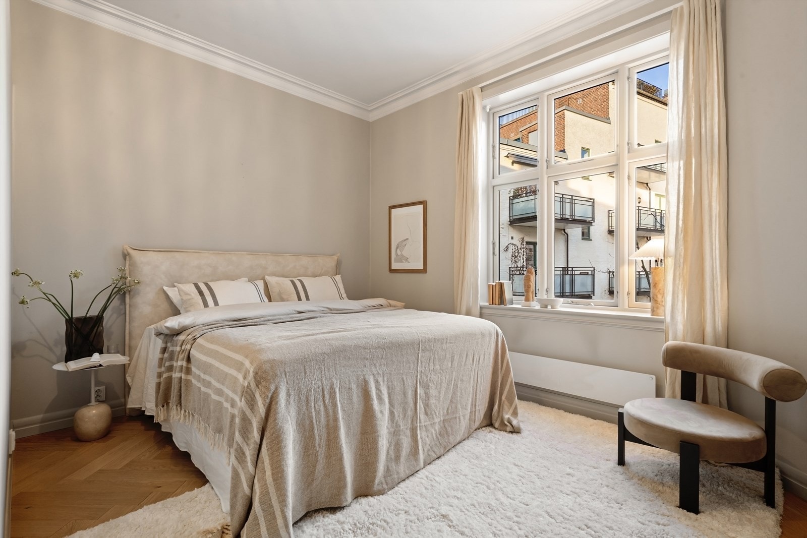 Romslig soverom med god plass til stor dobbeltseng, nattbord og øvrig møblement Galleribilde