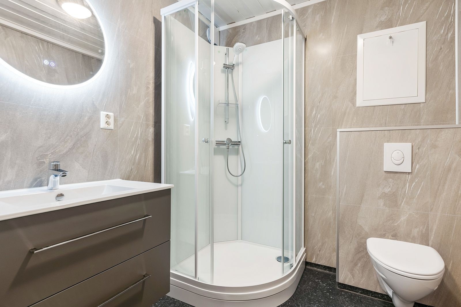 Nyere renovert bad med dusjkabinett og vegghengt toalett. Galleribilde