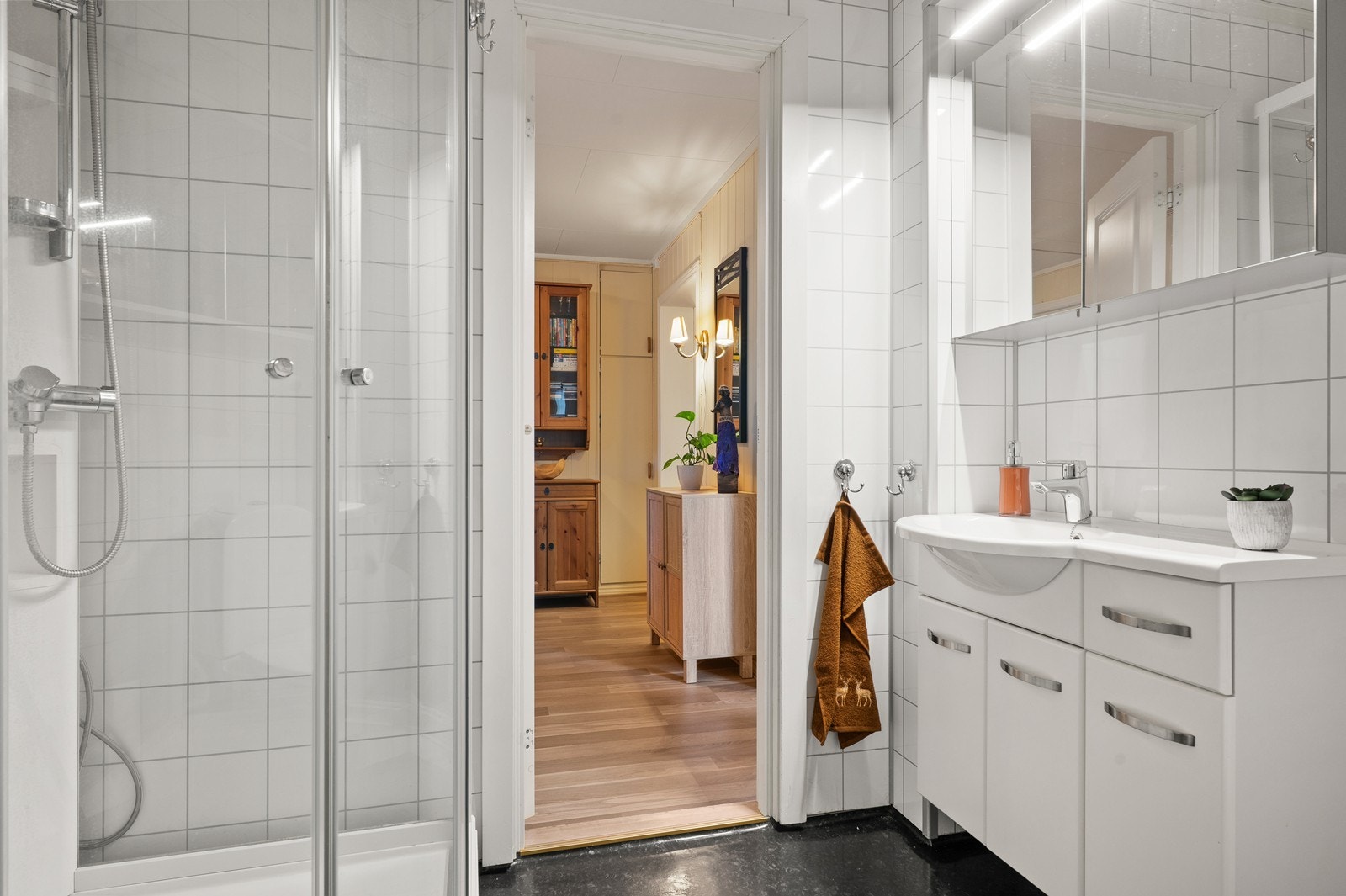 Badet er innredet med servant, toalett, dusjkabinett og opplegg for vaskemaskin. Galleribilde