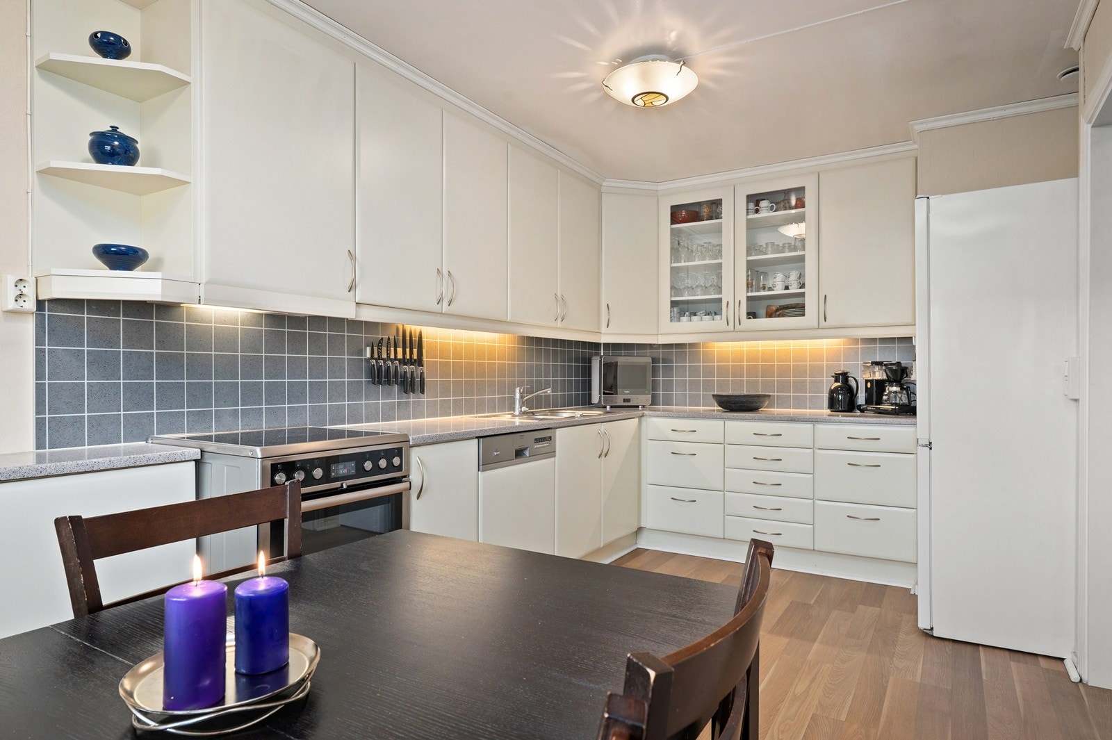 Kjøkkenet har lyse glatte fronter og benkeplate av laminat. Her det det godt med skap- og benkeplass. Galleribilde