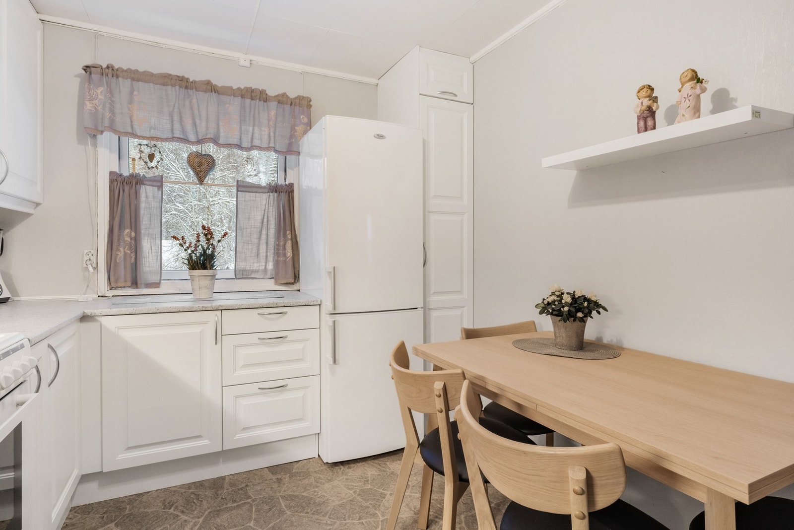 Kjøkkeninnredning med
hvite profilerte fronter og laminert benkeplate med nedfelt oppvaskkum. Galleribilde