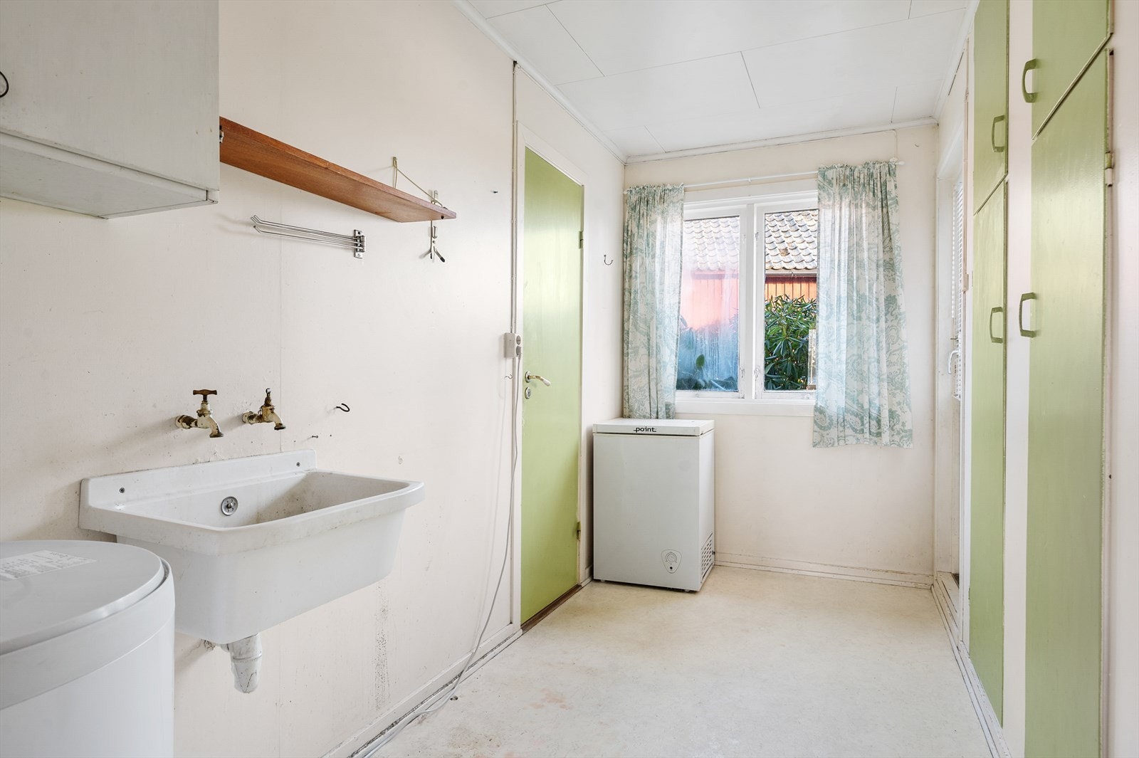 Praktisk vaskerom med plassbygde skap, utslagsvask og egen utgang. Galleribilde