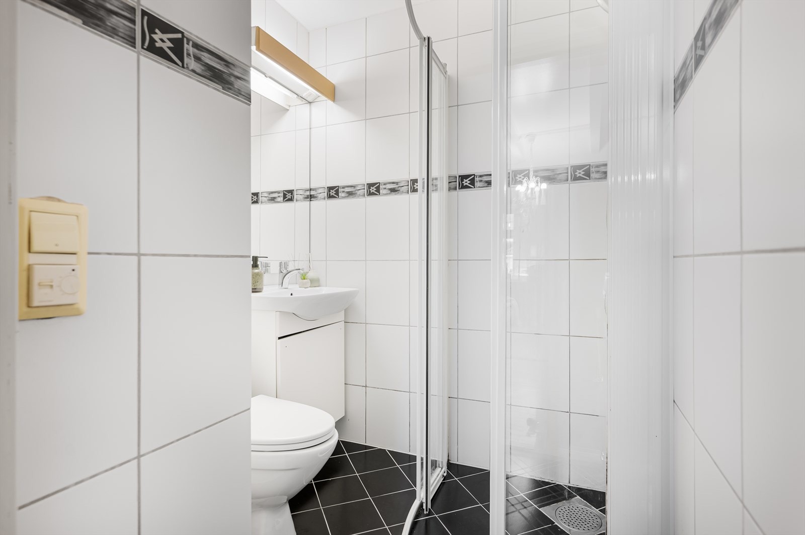 Badet har fliser på både vegger og gulv, samt gulvvarme for komfort. Galleribilde