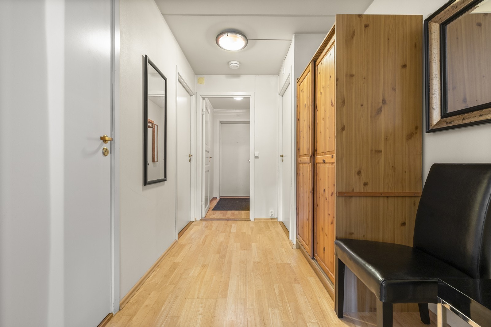 Fra entréen ledes du inn i en gang med parkett på gulvet som binder rommene sammen. Galleribilde