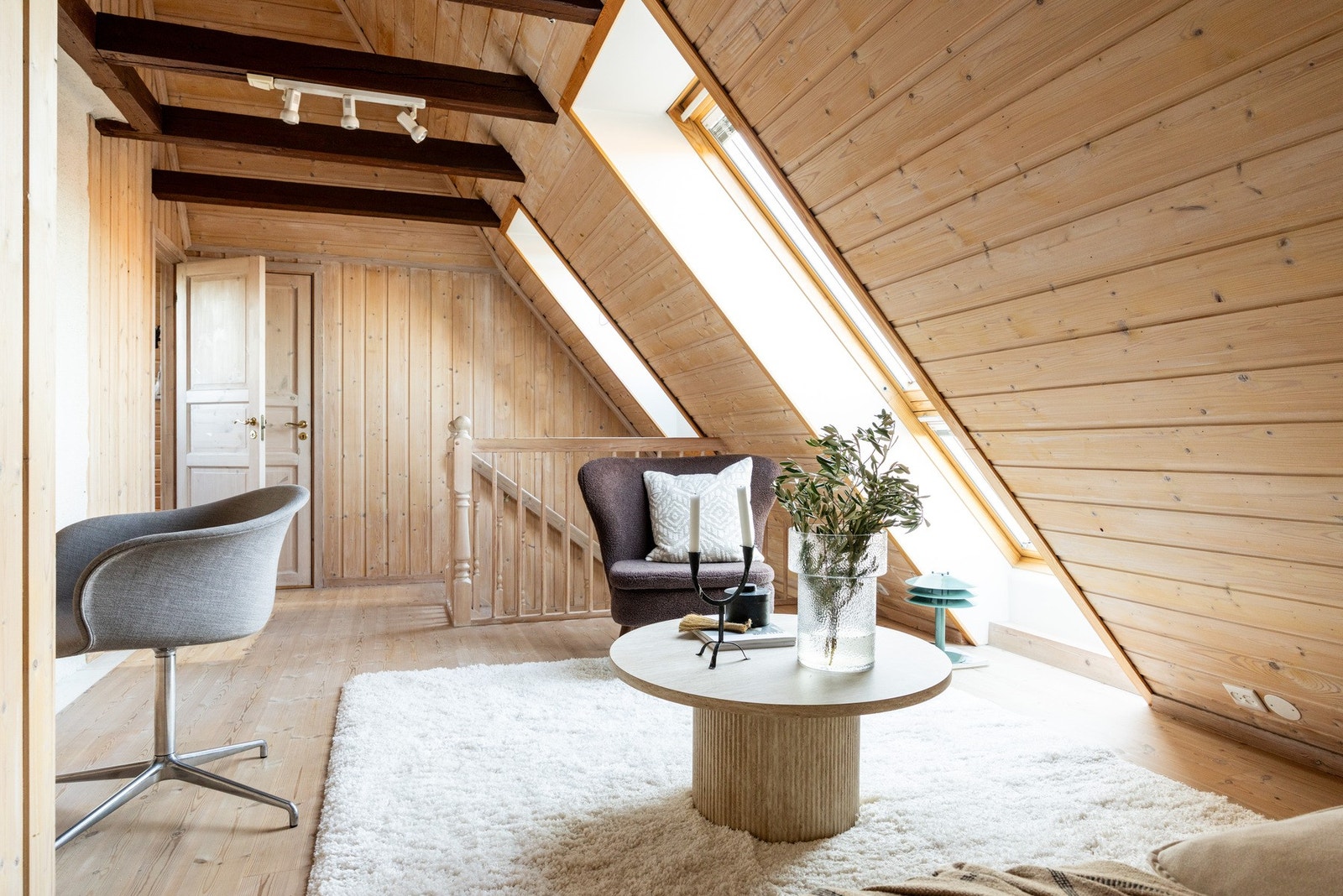 I andre etasje finner man en sjarmerende og lun stue med gjennomgående trepanel, skråtak og synlige bjelker som gir rommet en varm og karakterfull atmosfære. Galleribilde