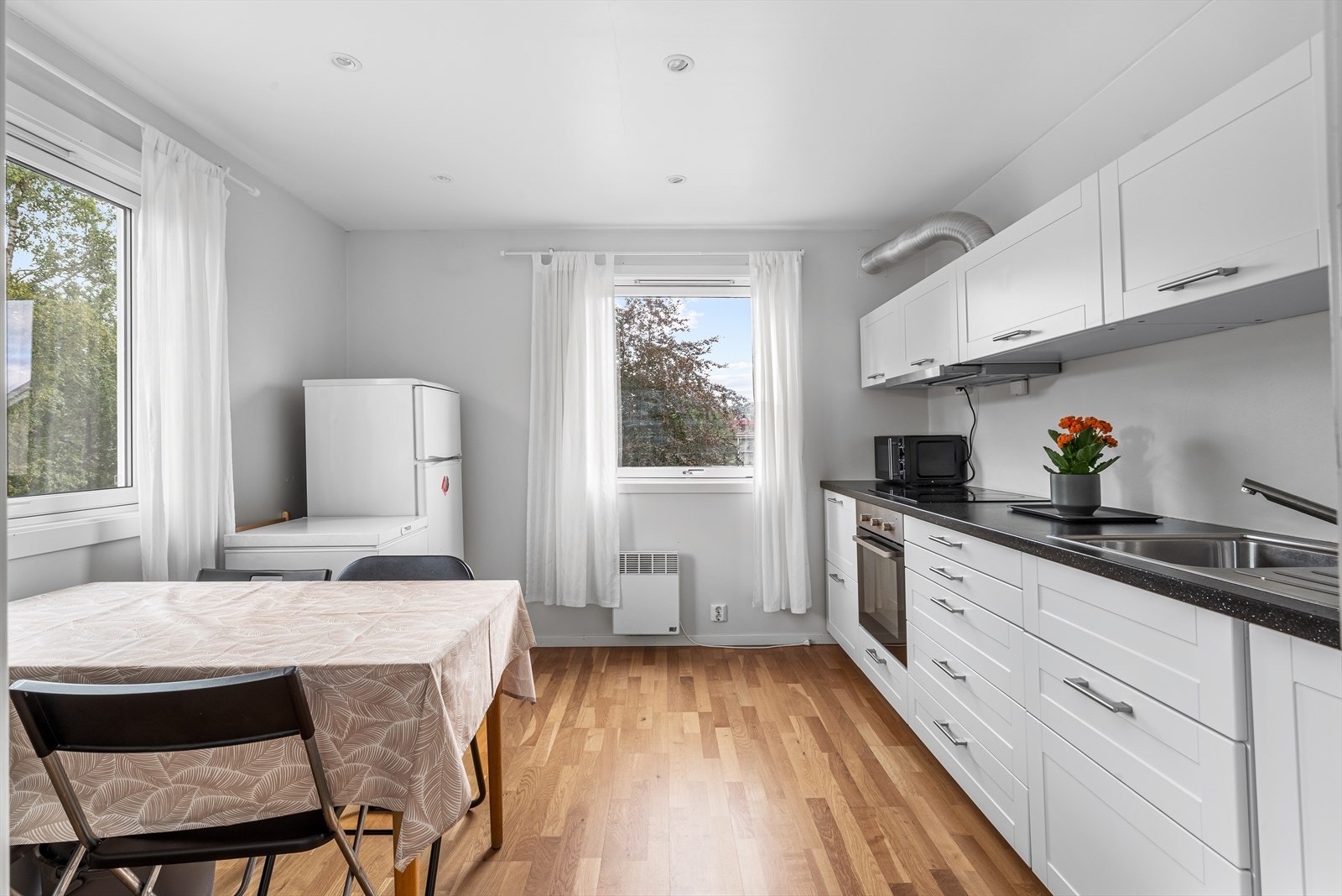 Kjøkkenet i leiligheten i andre etasje har også en stilren innredning med delvis integrerte hvitevarer Galleribilde