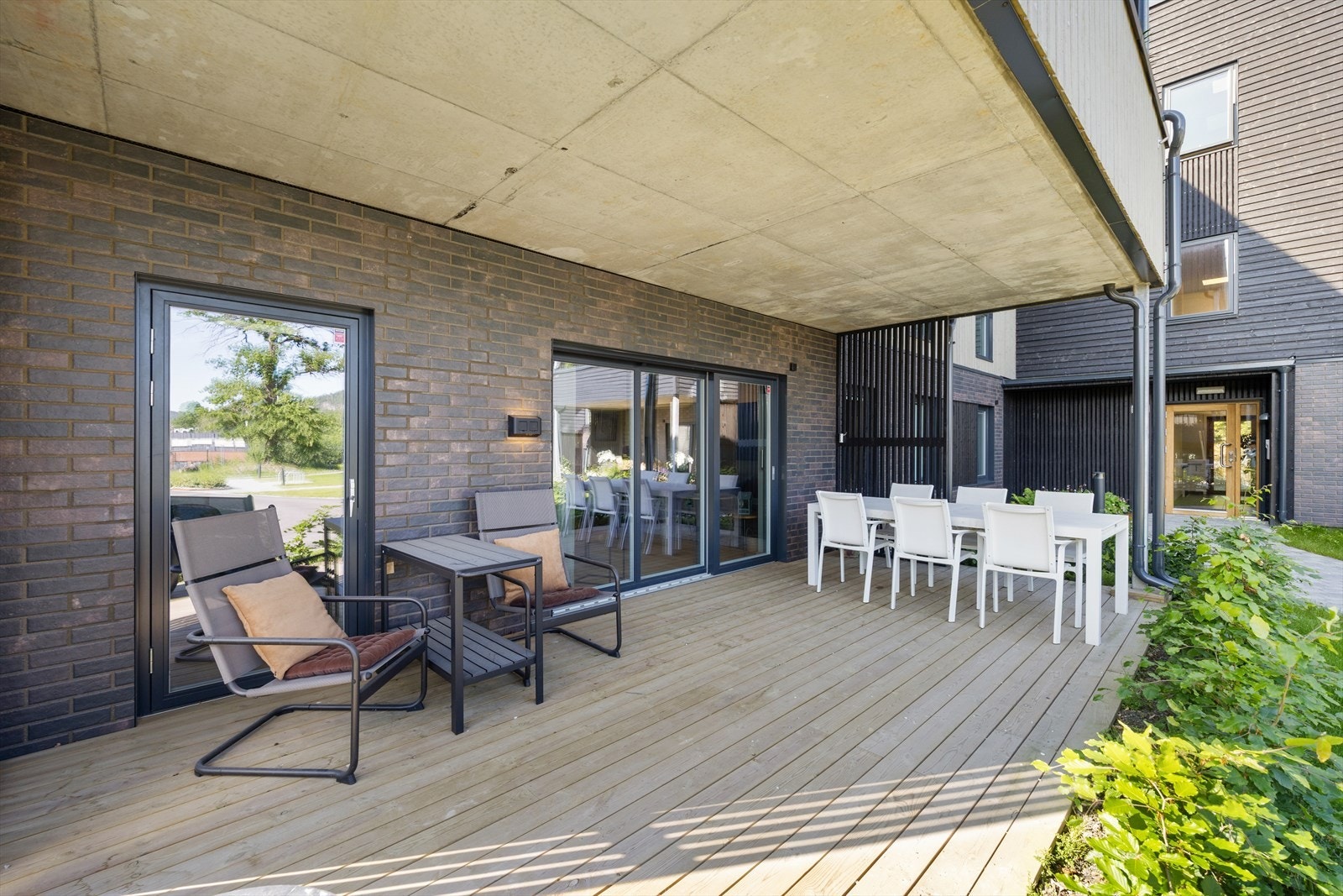 Fra stuen fører en skyvedør ut til en overbygget terrasse med god plass til både spiseplass og lounge. Galleribilde