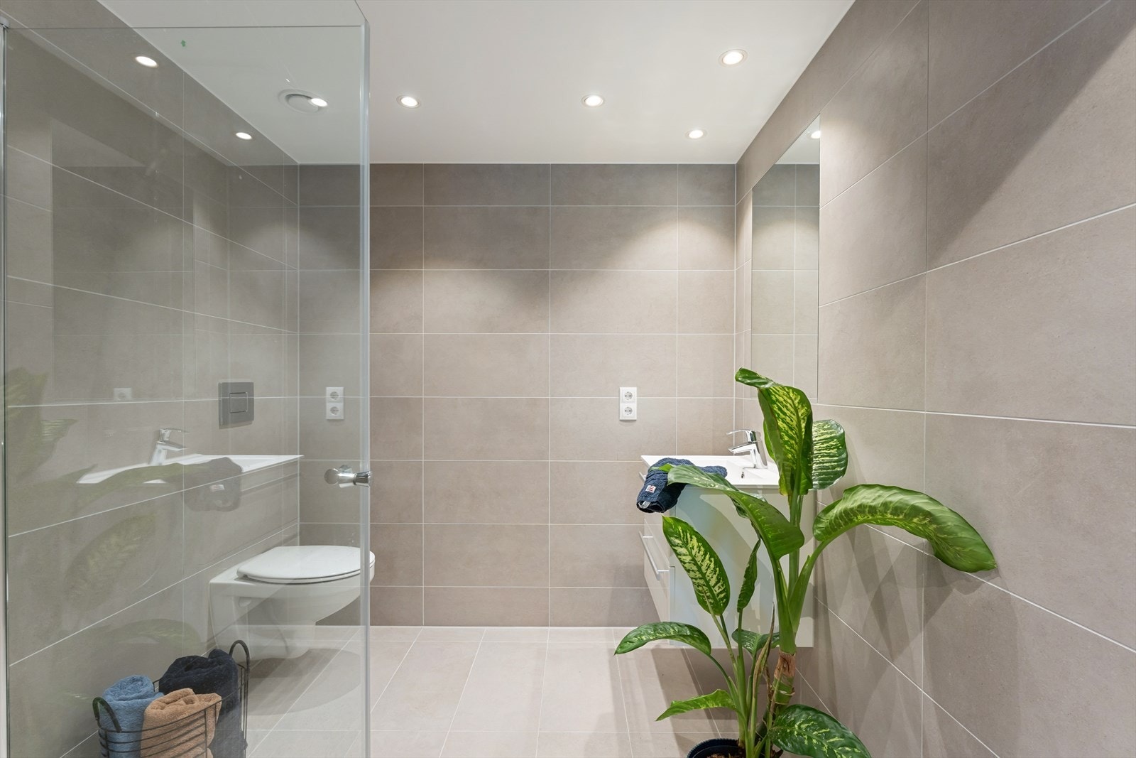 Hovedbadet ligger i direkte tilknytning til hovedsoverommet og er flislagt med delikate sandtonede fliser og gulvvarme. Galleribilde