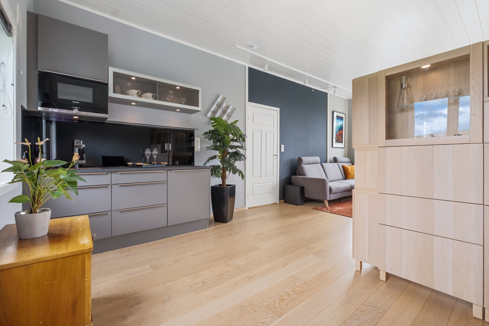 I åpen løsning finner du kjøkken fra JKE med integrert benkekjøleskap og mikro Galleribilde