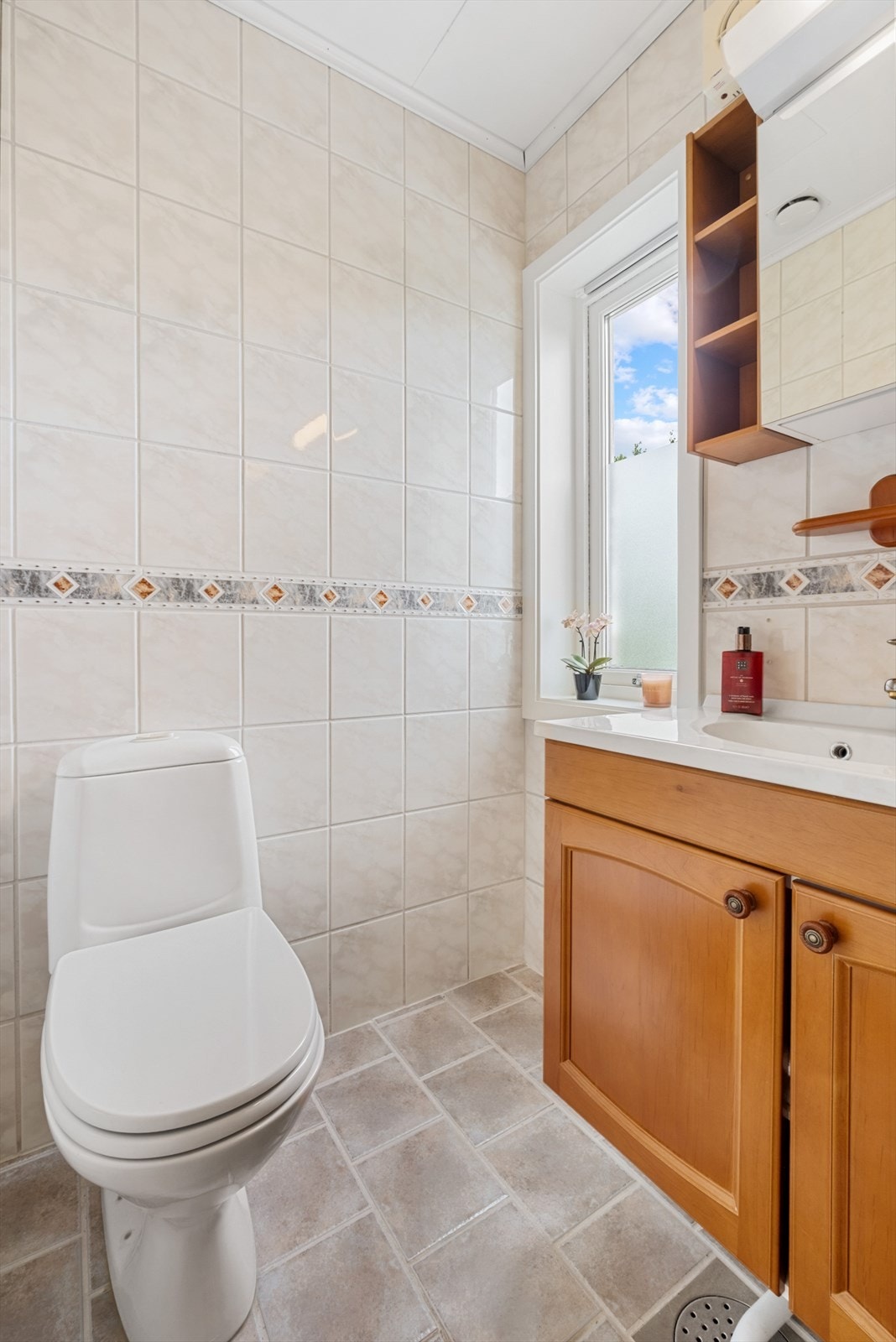 Badet har gulvstående toalett, dusjkabinett og baderomsinnredning Galleribilde