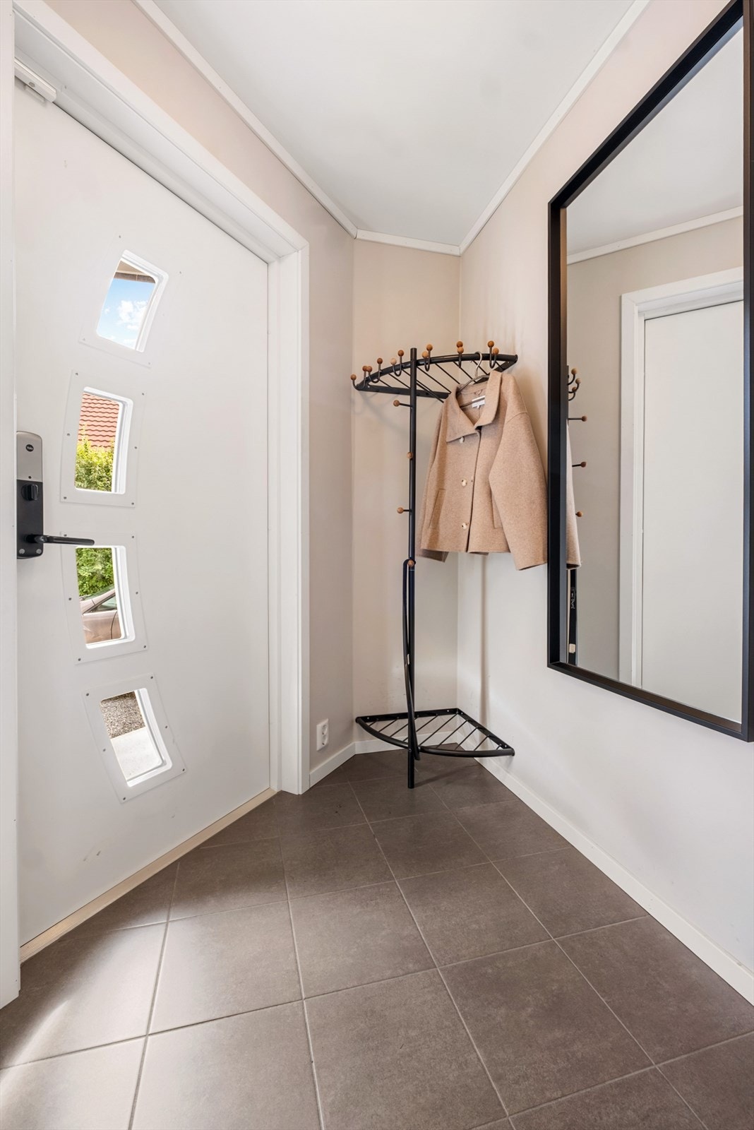 Du ønskes velkommen inn i en hyggelig flislagt entrè med plass til å henge fra seg yttertøy Galleribilde