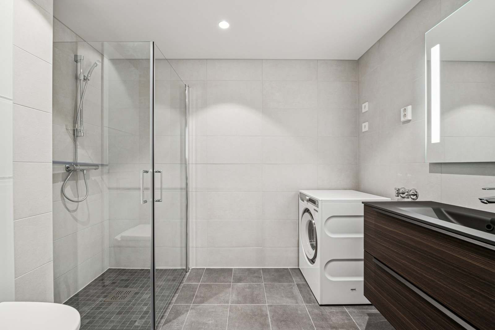 Delikat bad med moderne flislagte overflater, gulvvarme og downlightsbelysning. Galleribilde