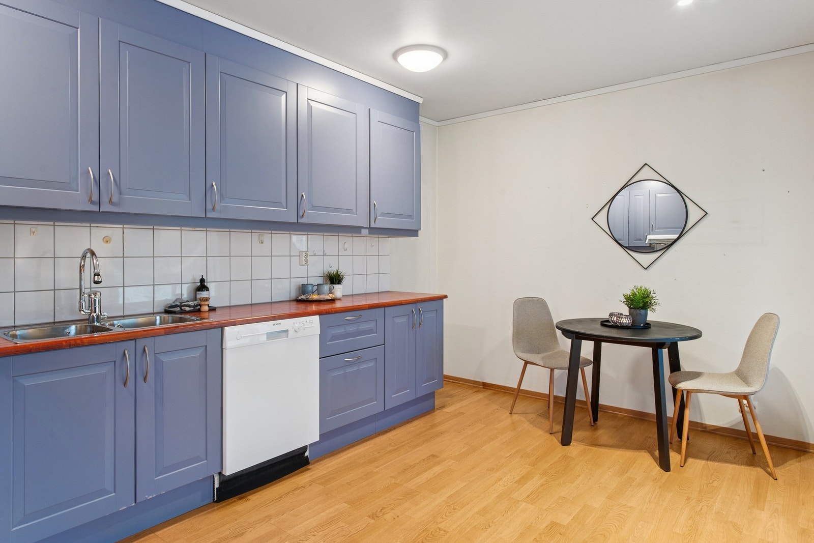 Innredningen har laminert benkeplate, fliser over benken og opplegg for oppvaskmaskin. Galleribilde