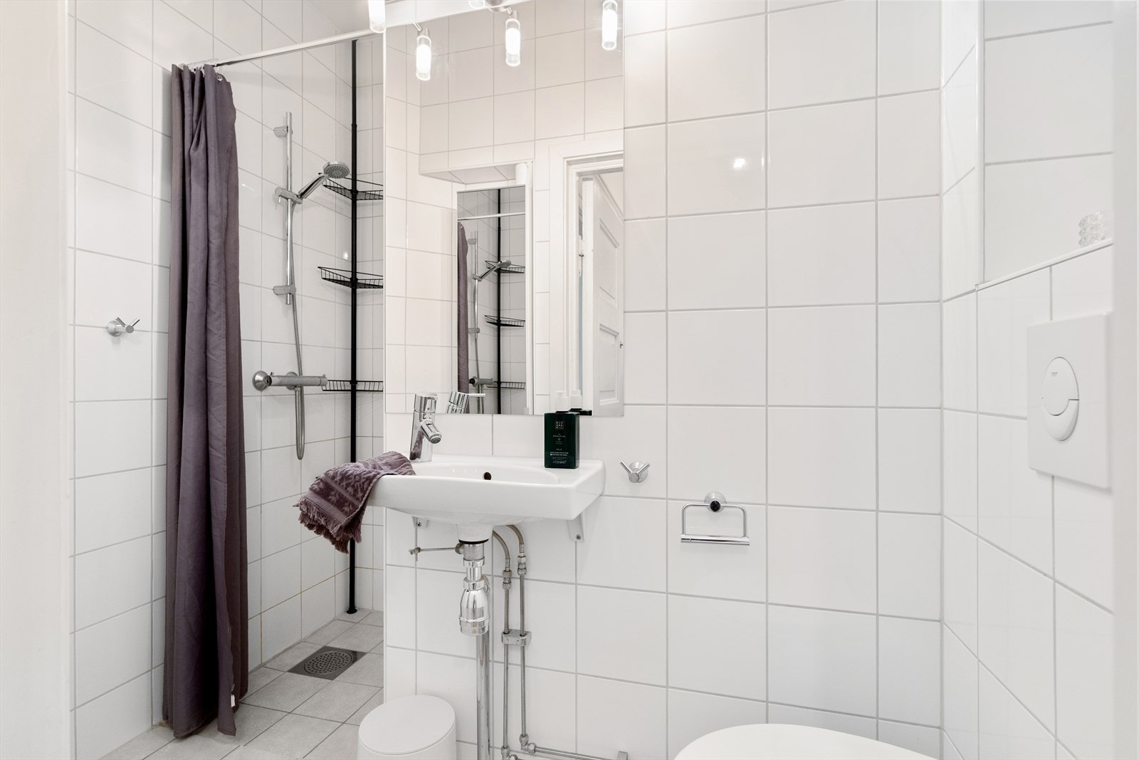 Pent bad fra 2012 med naturlig avtrekk, dusjnisje, veggmontert wc og servant med ettgreps blandebatteri fra Hansgrohe. Galleribilde