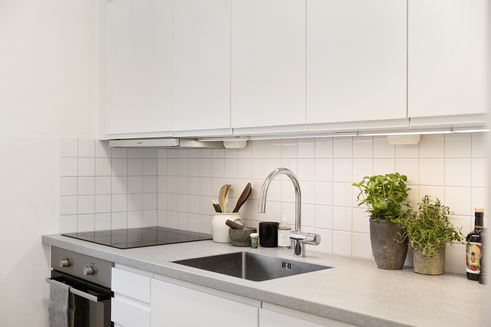 Ellers er kjøkkenet utstyrt med ettgreps blandebatteri fra Damixa. Innredningen er utstyrt med benkebereder, kombiskap og mekanisk avtrekk over stekesonen. Integrert oppvaskmaskin, platetopp og stekeovn. Galleribilde