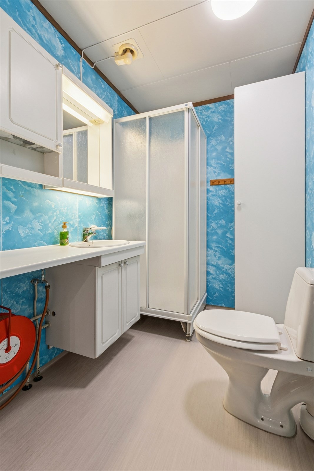 Eldre bad med moderniseringsbehov. Utstyrt med dusjkabinett, gulvstående toalett og lys baderomsinnredning. Galleribilde