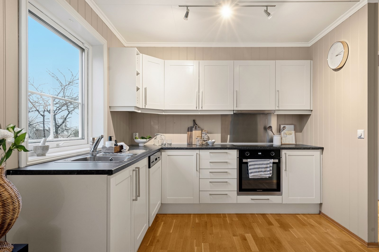 Kjøkkenet har profilerte fronter og laminat benkeplate, med integrerte hvitevarer som oppvaskmaskin og komfyr. Galleribilde