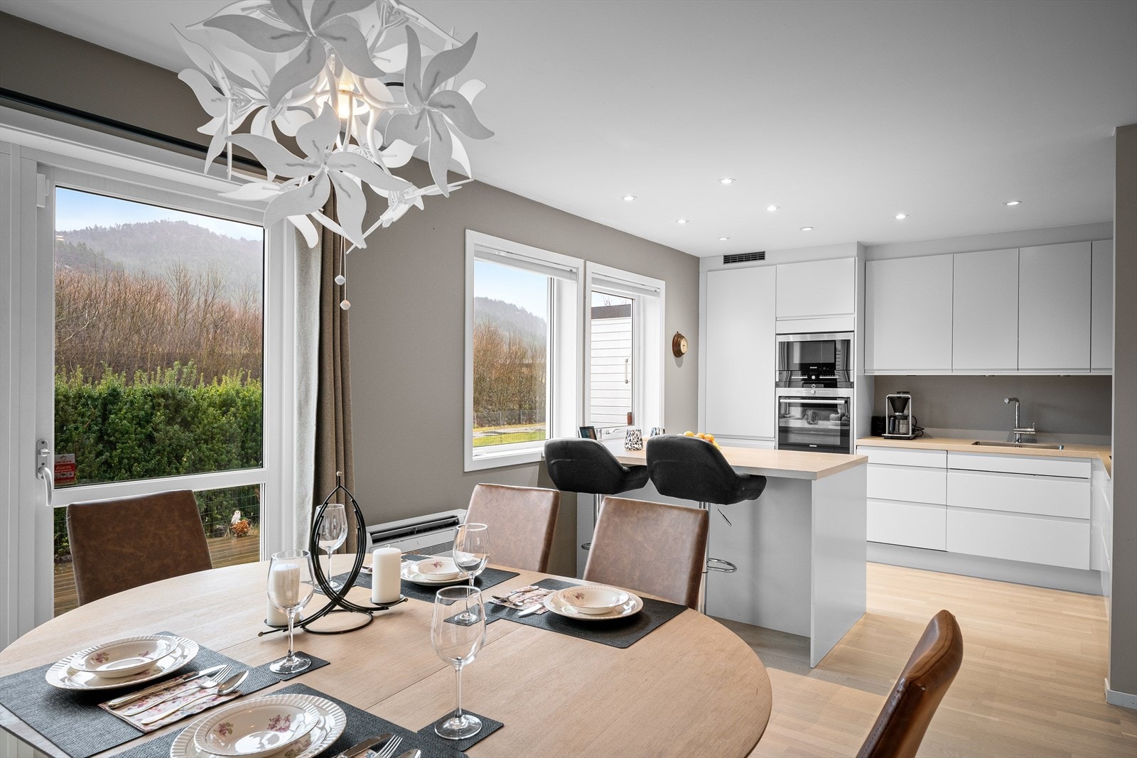 Moderne og lyst kjøkken med hvite fronter og benkeplate i lys eik. Galleribilde