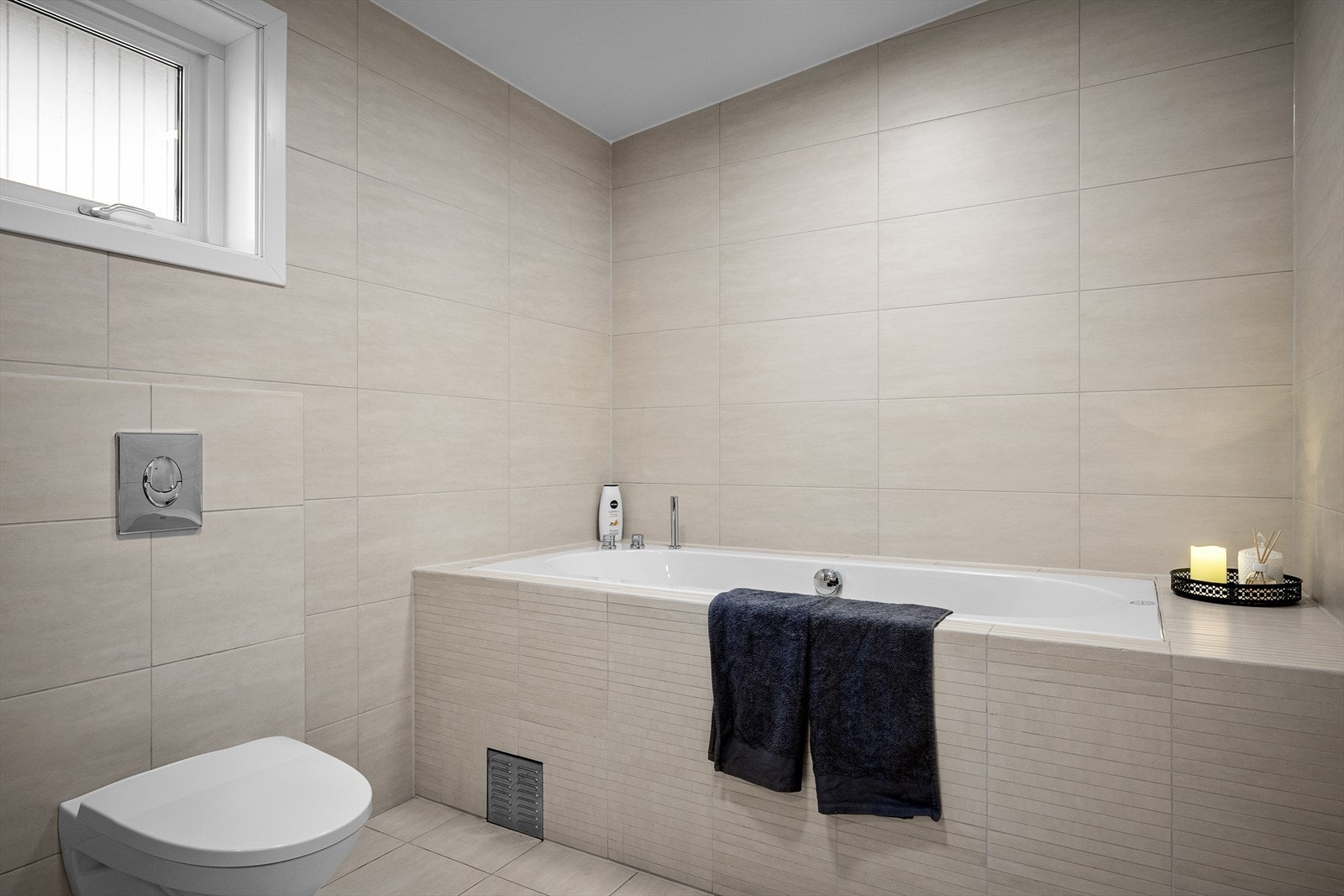 Badet er utstyrt med servant, vegghengtoalett og badekar. Galleribilde