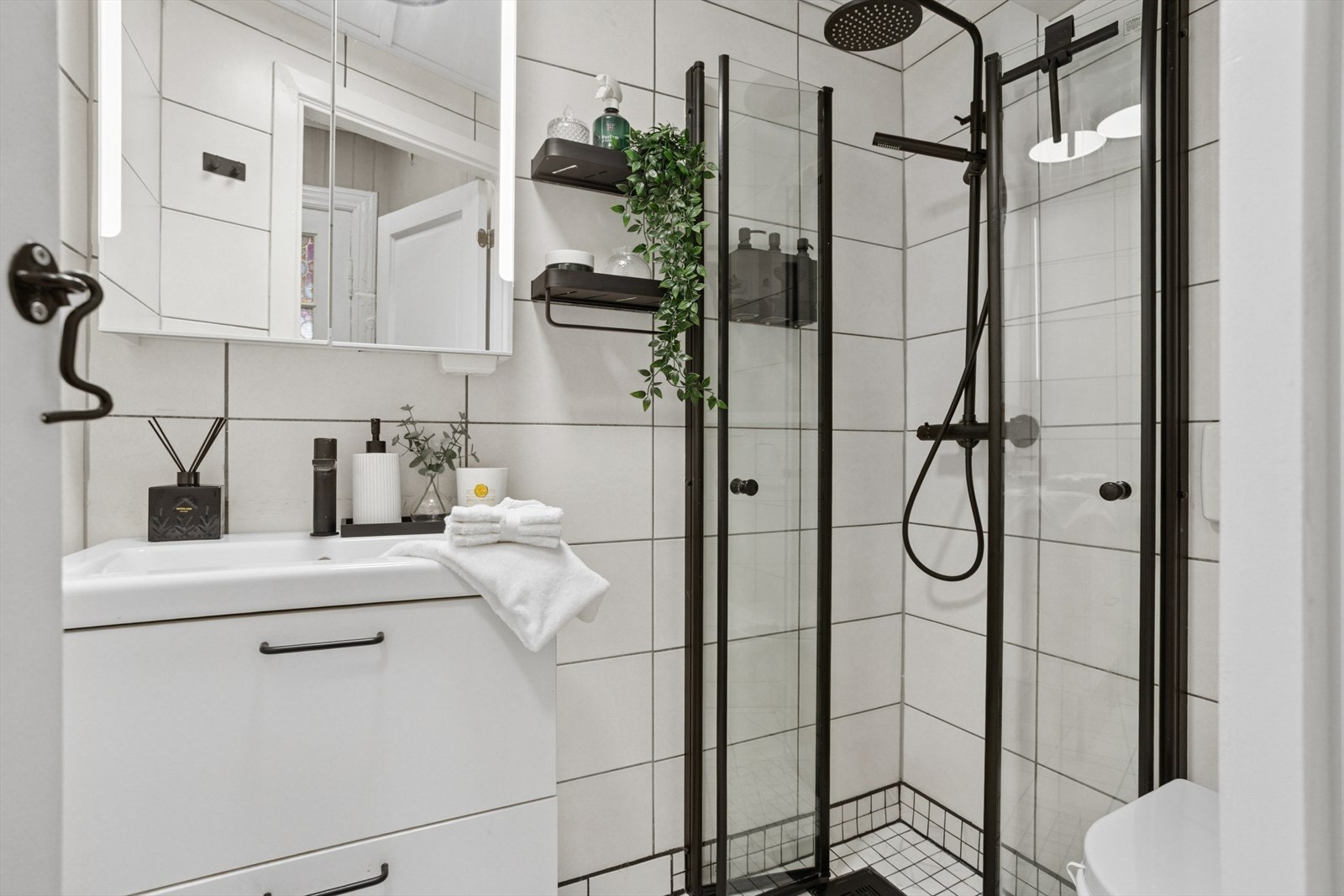 Baderom med vask, dusj og toalett. Innfellbare glassdører som skaper en praktisk løsning. Galleribilde