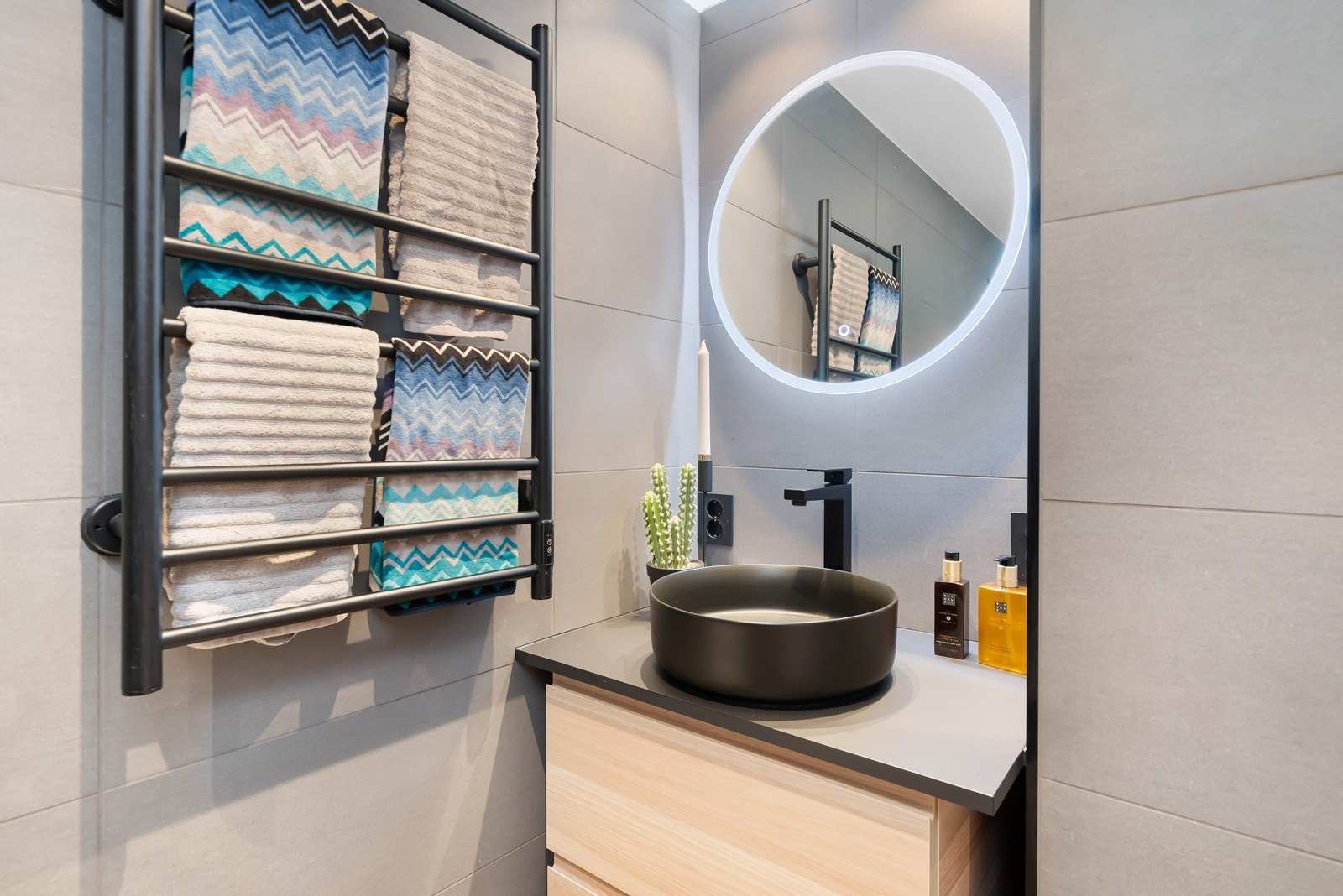 Badet er lekkert innredet med vegghengt servant med skuffer, speil med lys og stikkontakt Galleribilde