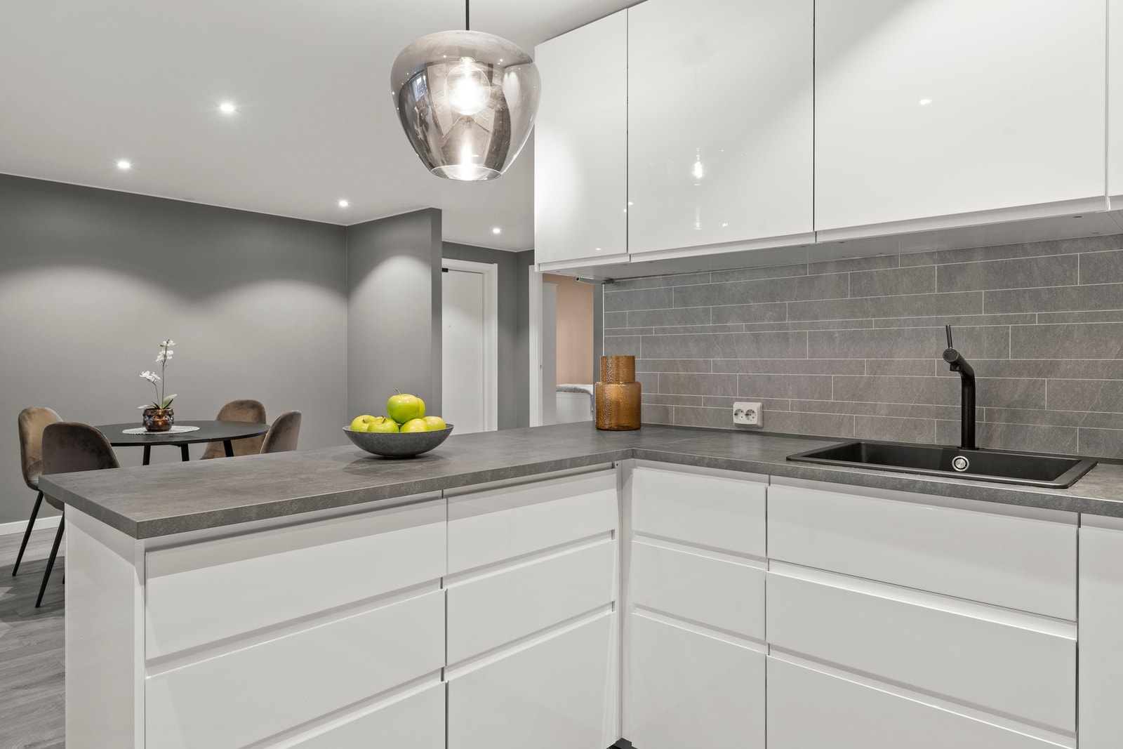 De integrerte hvitevarene gir kjøkkenet et stilrent og helhetlig uttrykk, og bidrar til både funksjonalitet og estetikk. Løsningen omfatter platetopp, stekeovn, oppvaskmaskin samt kjøleskap med fryser, sømløst integrert i innredningen for et ryddig og mod Galleribilde