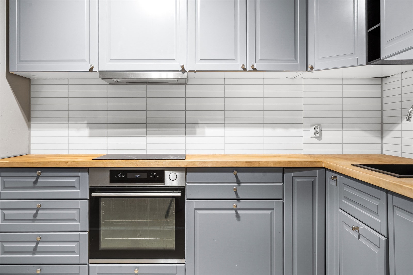 Kjøkkeninnredningen er utstyrt med benkeplate av treverk, sortlakkert oppvaskkum med 1-greps armatur, laminerte plater (flisimitasjon) på vegg. Videre er det stekeovn, platetopp og frittstående kjøleskap med frysedel. Tillaget skap for oppbevaring i vegg. Galleribilde