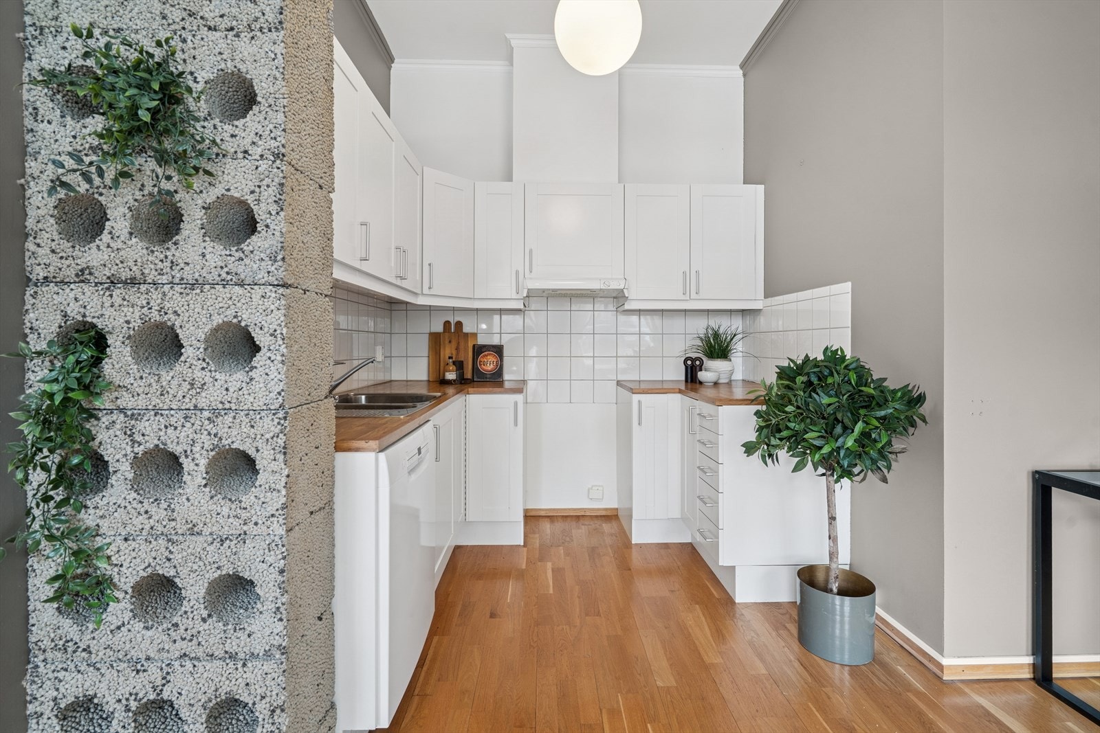 Kjøkkenet har hvit innredning med profilerte fronter og benkeplate av laminat. Galleribilde