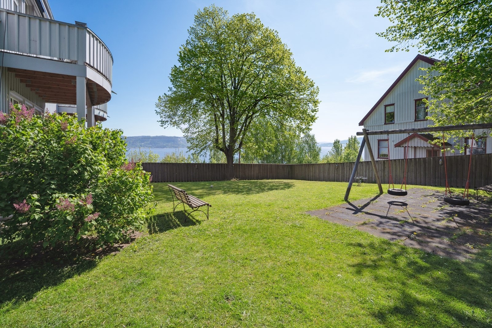 Pent opparbeidede fellesarealer med gressplen, beplantninger og lekeplass. Galleribilde