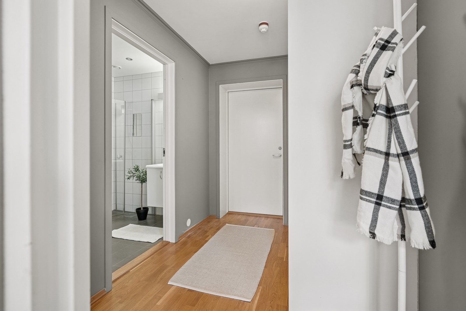 Inne i leiligheten møtes man en lys og innbydende entré med gode oppbevaringsmuligheter i skyvedørsgarderobe. Galleribilde