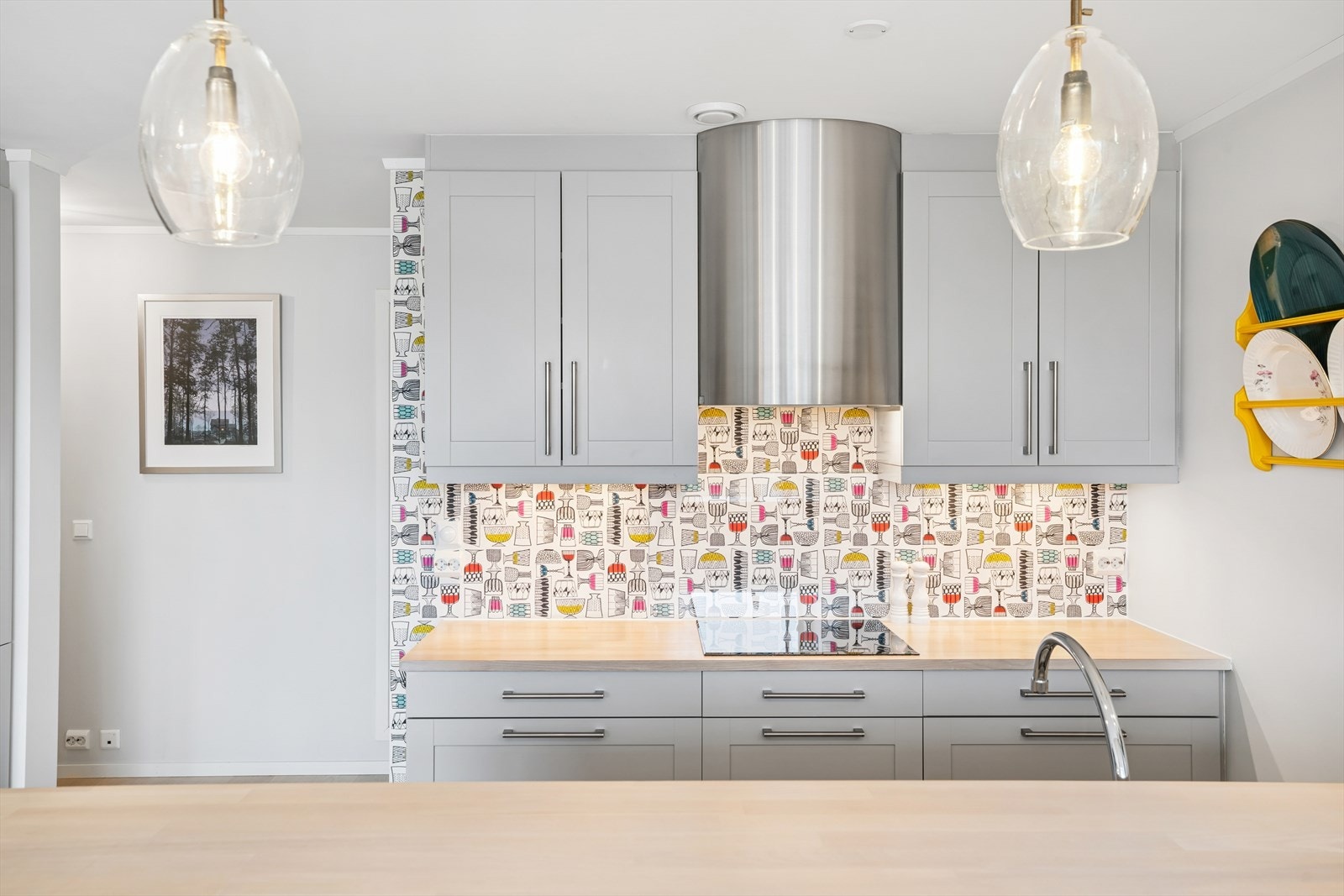 Praktisk arbeidssone med god belysning og glassplate bak koketoppen. Galleribilde