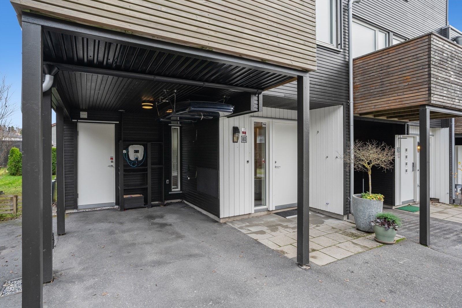 Parkering i carport med lader og på p-plass ved siden av carport. Galleribilde