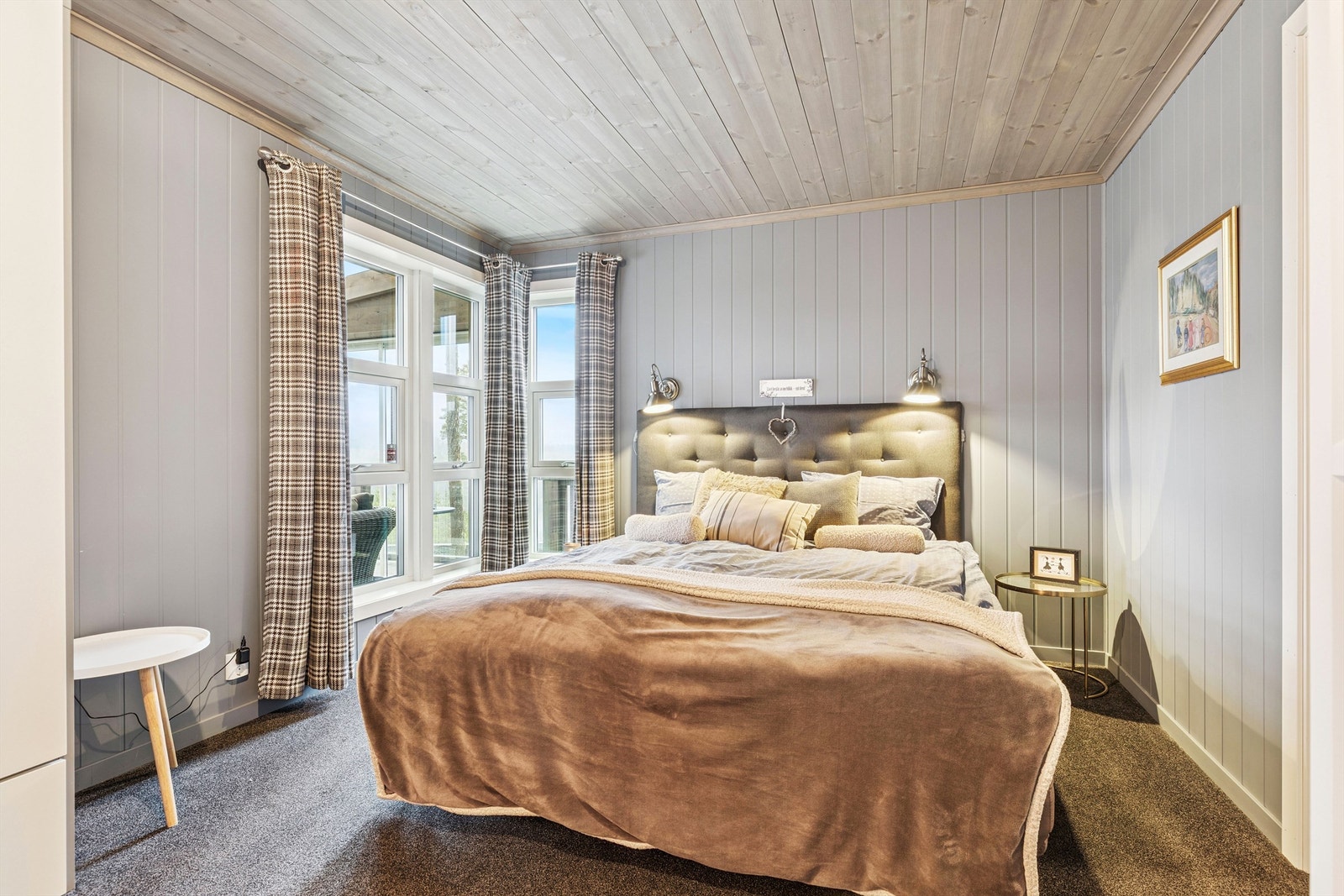 Hovedsoverommet har teppe på gulvet og beiset trepanel i himlingen for en lun følelse. Galleribilde