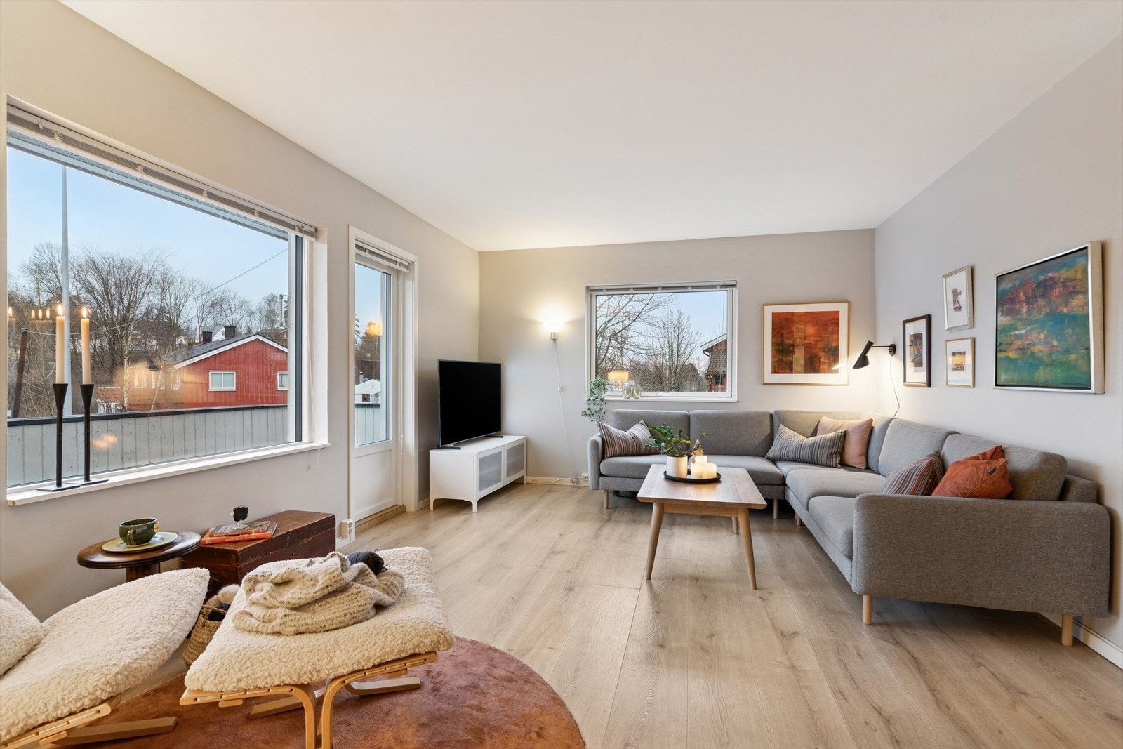 Stuen er romslig og har store vindusflater som gir rikelig med naturlig lys. Her har man lysmalte, slette overflater med listefrie overganger til tak som gir et moderne og stilrent uttrykk. Galleribilde