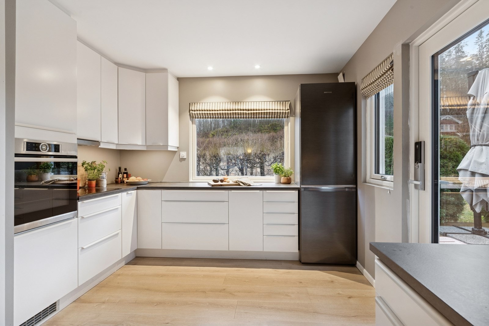 Kjøkkenet er levert av Ikea og ble oppgradert med nye fronter og ny benkeplate i 2020. Et stilrent kjøkken med hvite, slette fronter og grå benkeplate i laminat. Her har man rikelig med skap- og skuffeplass, samt gode arbeidsflater på benk. Galleribilde